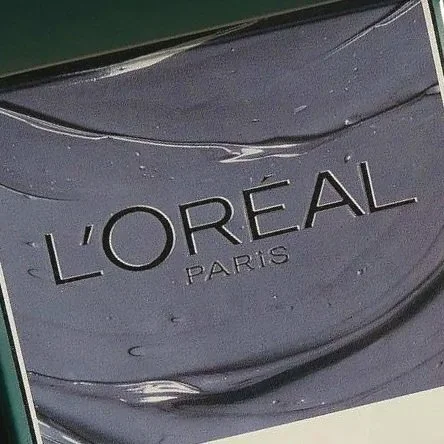 Close-up of L'Oréal Paris logo on a dark cosmetic container.