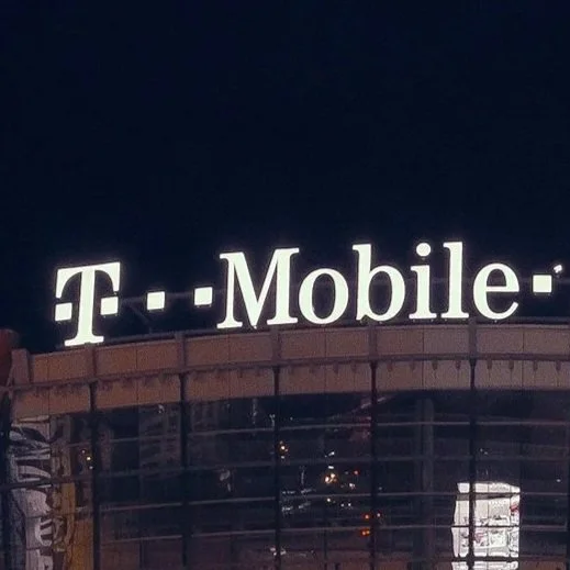 T-Mobile store sign at night with illuminated logo.