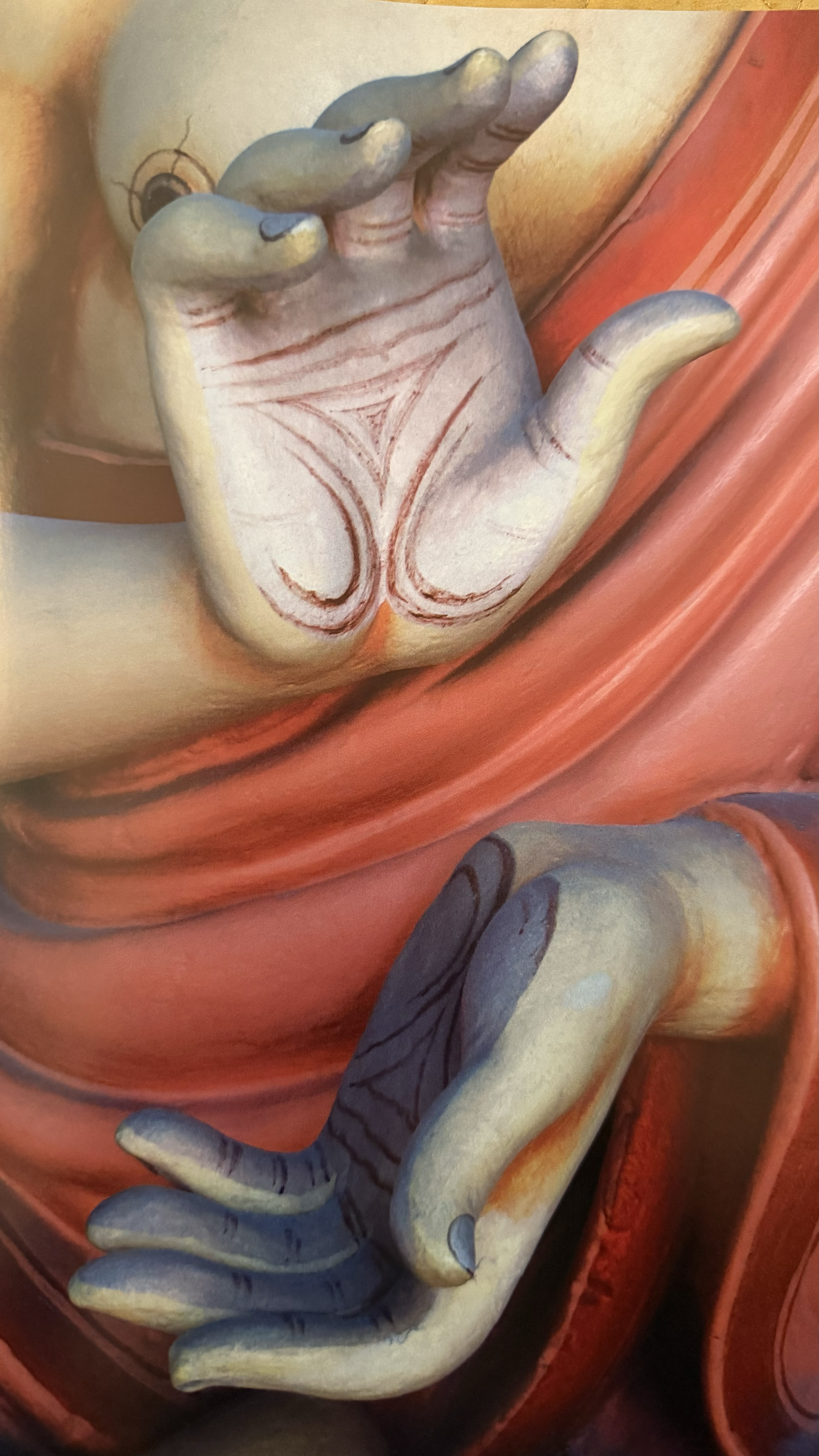 A painted depiction of a hand with detailed lines and shadows, positioned with palms and fingers in a specific gesture, which is part of a larger artistic image.