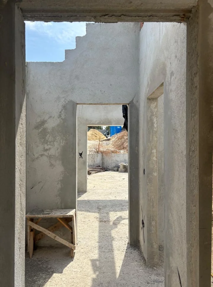 View of a construction site with unfinished walls and doorways in a building under construction.