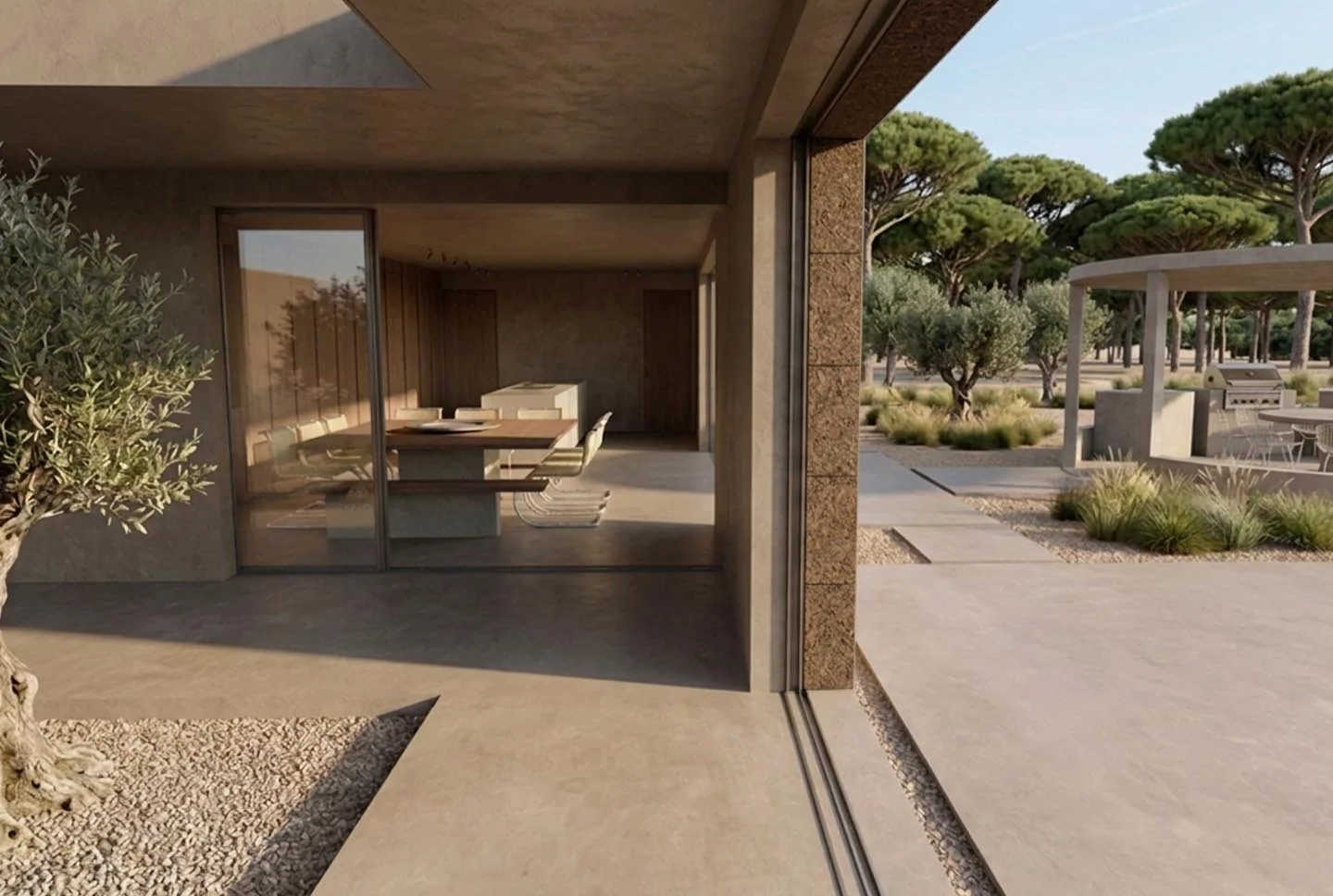 Interior view of a modern house with a large glass sliding door opening to an outdoor patio area with trees and bushes.