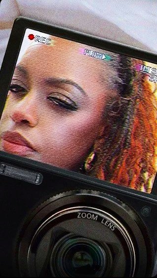 A camera's LCD screen showing a woman's face in focus.