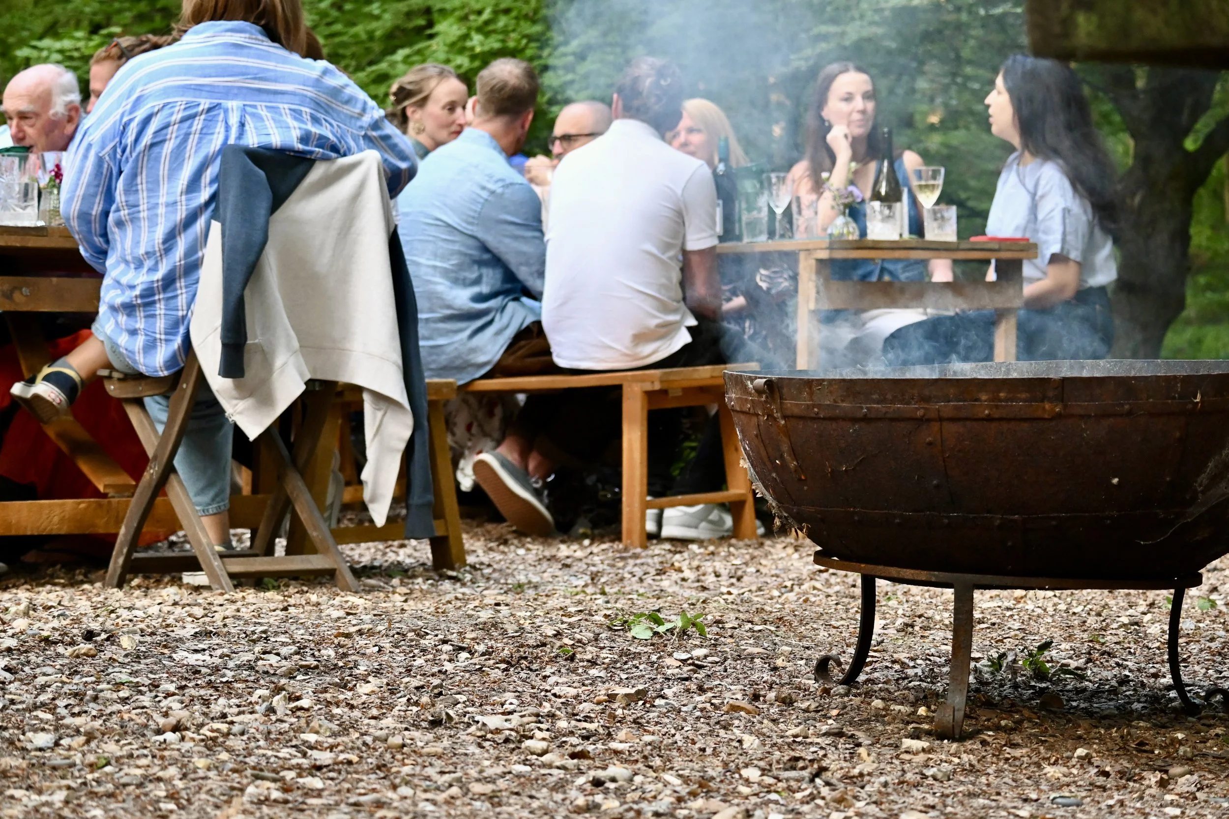 diners eating and drinking at outdoor woodland feast Chilterns