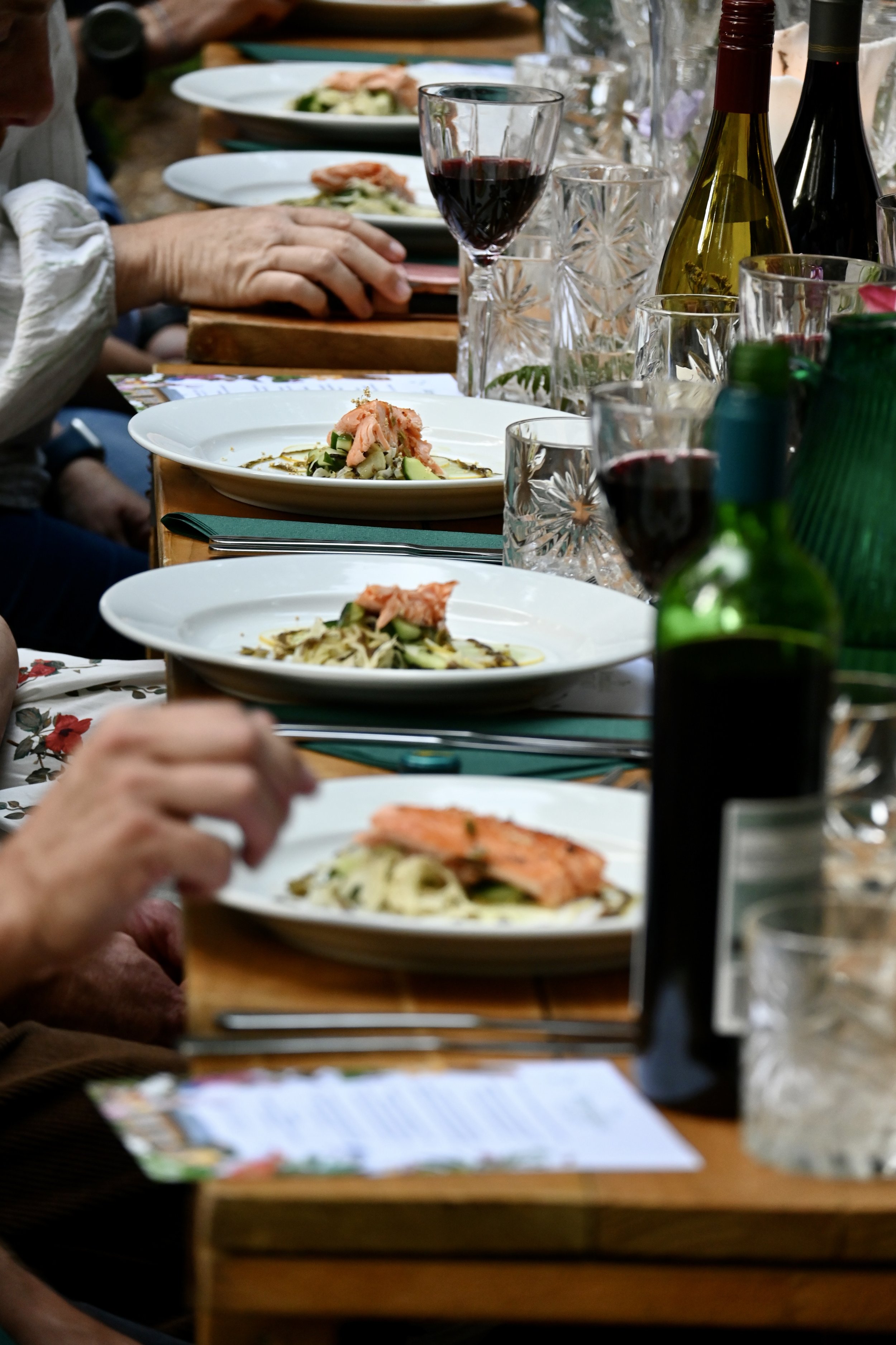 diners eating and drinking at outdoor woodland feast Chilterns