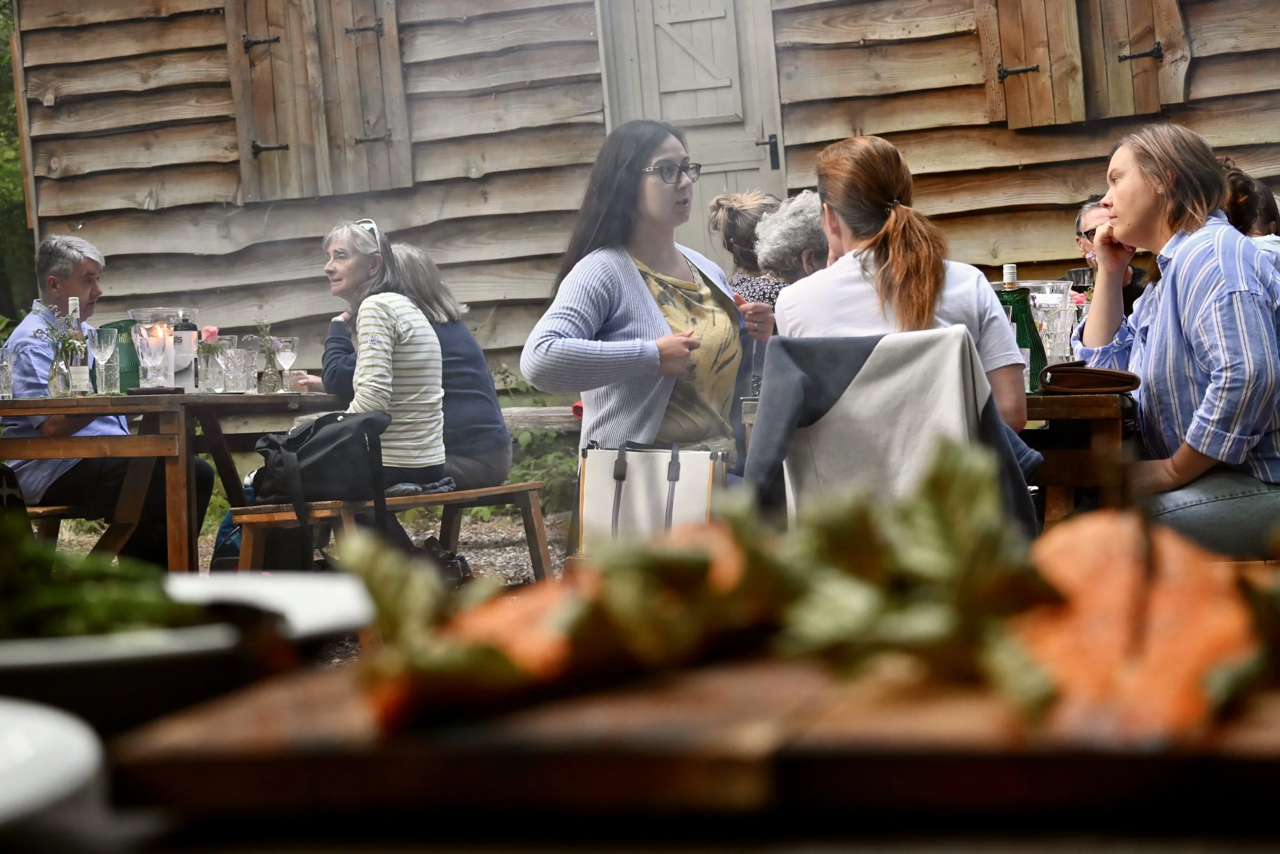 diners eating and drinking at outdoor woodland feast Chilterns