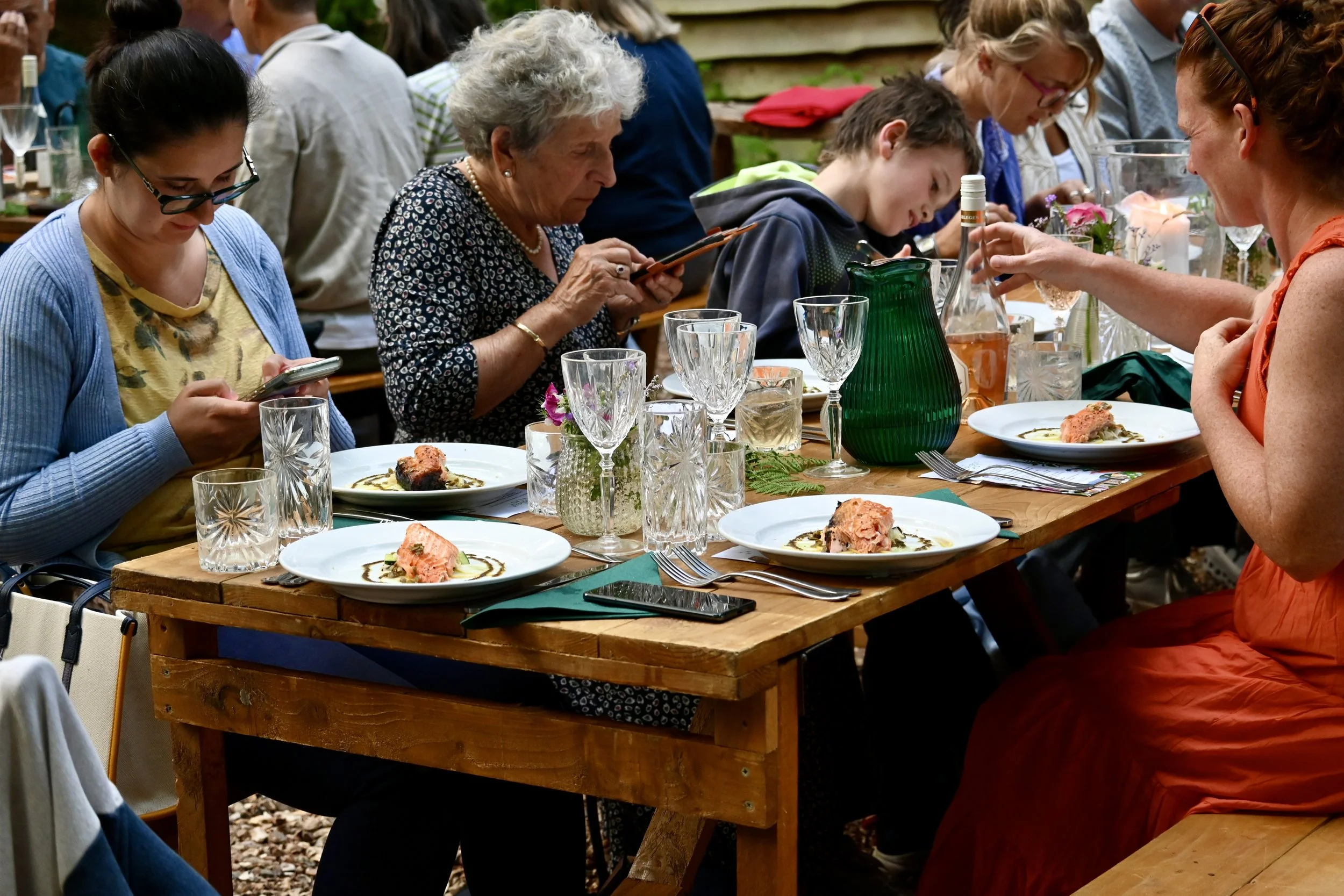 diners eating and drinking at outdoor woodland feast Chilterns