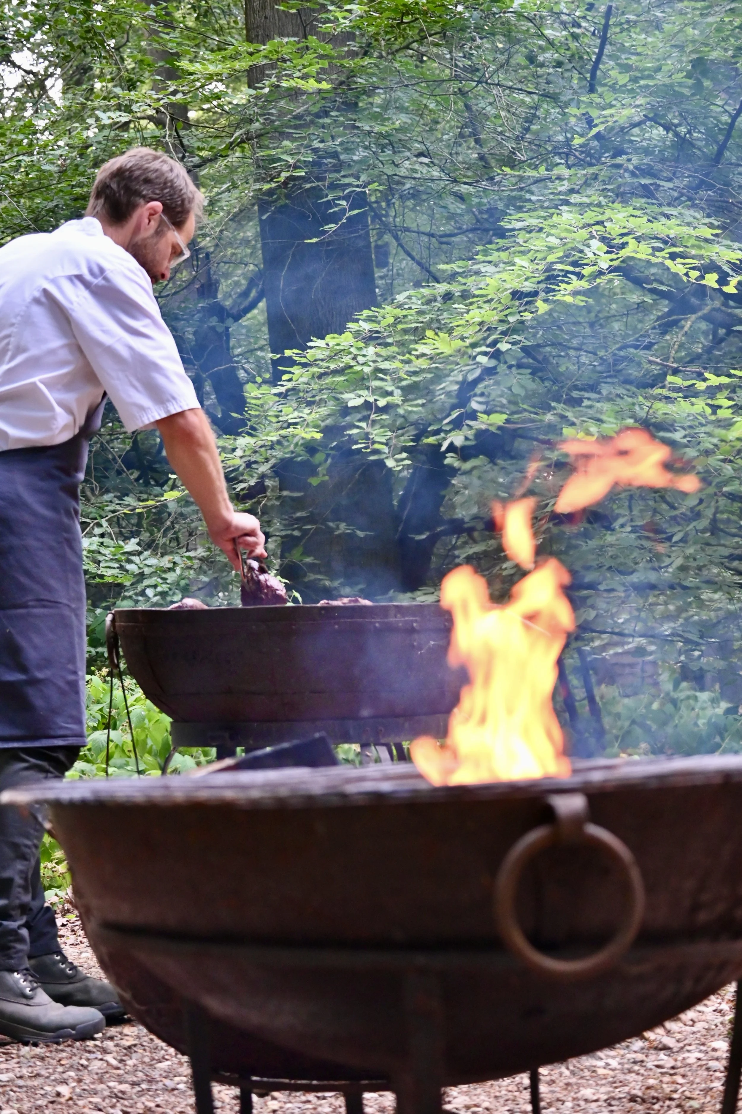 chef cooking over open fire Chilterns woodland