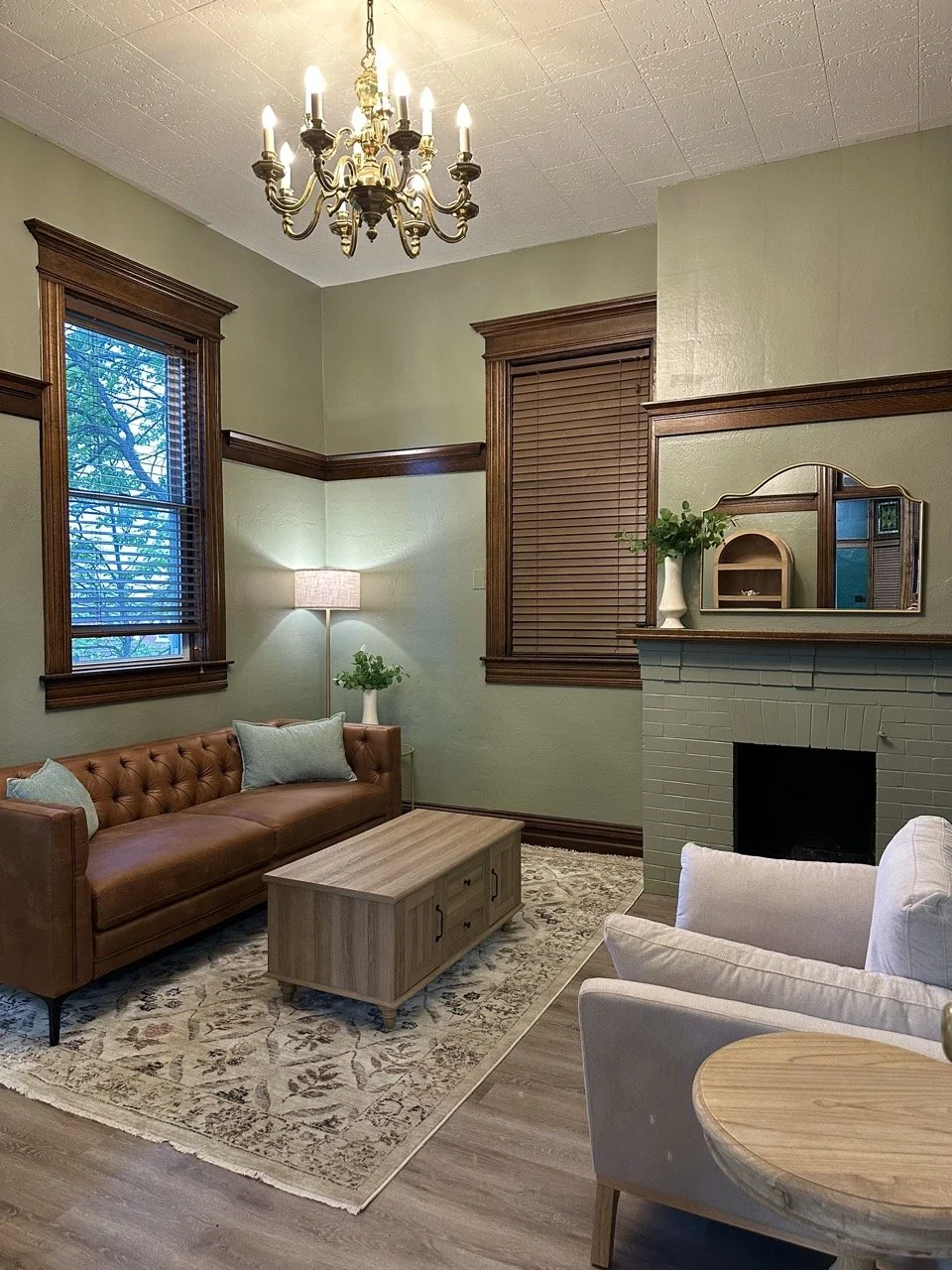 a room with a couch facing a chair and a coffee table