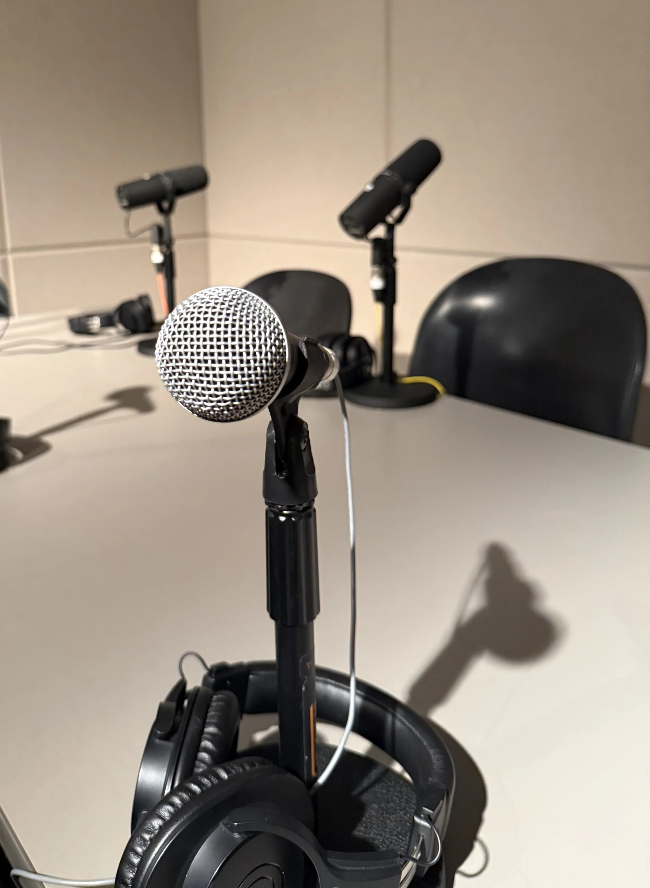 A set of microphones on a table, ready to record an episode of the Publishing Academic Research Podcast with C. Kyle Rudick, PhD