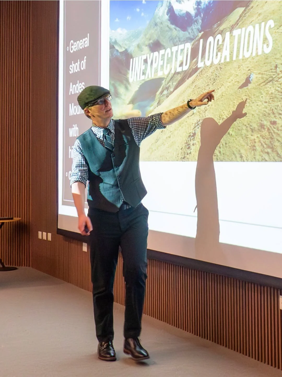 Dr. Kyle Rudick, pointing to a visual slide deck, giving a presentation on academic research