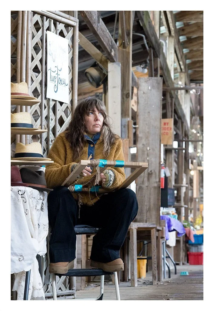 Kimberly Hutsal, a craft artisan specializing in unique handmade items, weaves a hat at her booth during the Ithaca Farmers Market in Ithaca, N.Y. Hutsal owns Two Foxes Studio, which has a second location in New York City, but she spends weekends per