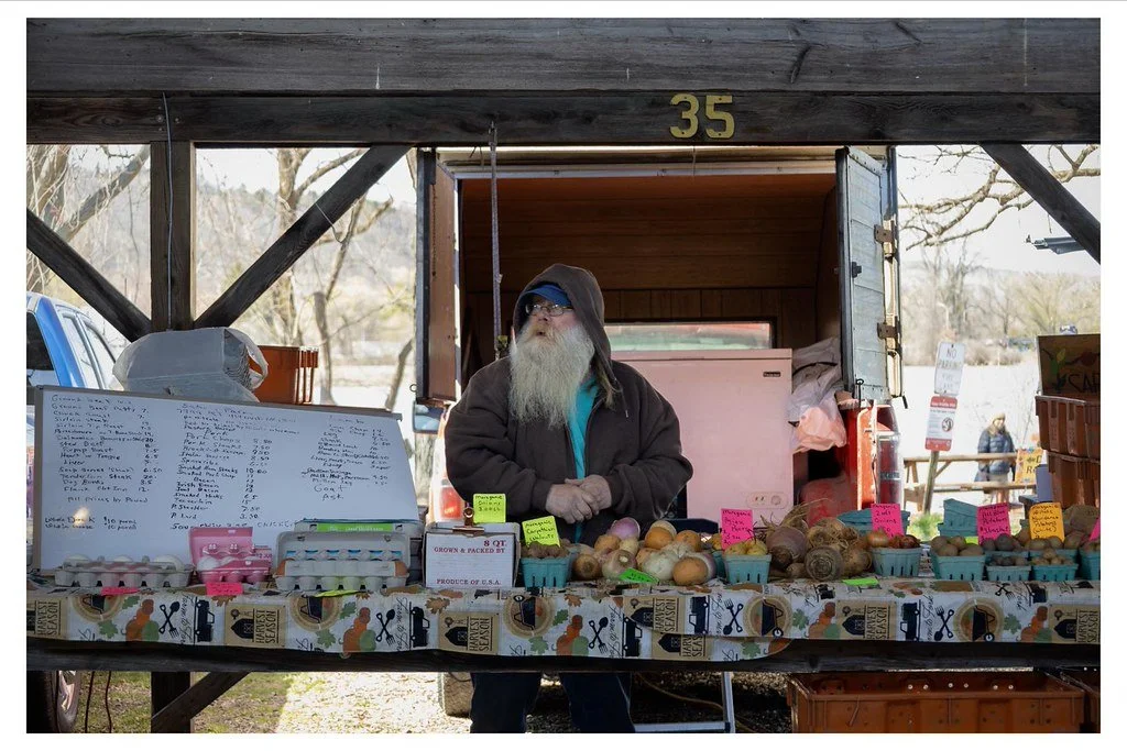 Richard Sabol, a third-generation farmer from Ovid, N.Y., arranges fresh produce at his booth at the Ithaca Farmers Market. Sabol and his partner, Sue, operate Sabol's Farm, selling their locally grown vegetables and meat products every weekend at th