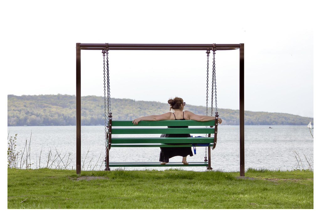 After a day's work, Tessa David unwinds on a swing bench overlooking Cayuga Lake at Stewart Park in Ithaca, New York. 