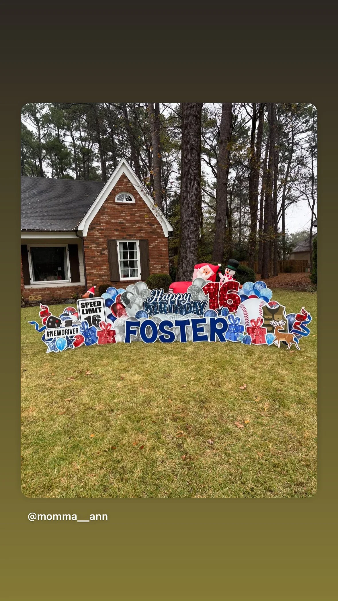 Outdoor birthday display with a large blue 'FOSTER' sign, Santa, snowman, reindeer, and various decorations for a 16th birthday celebration in front of a brick house.