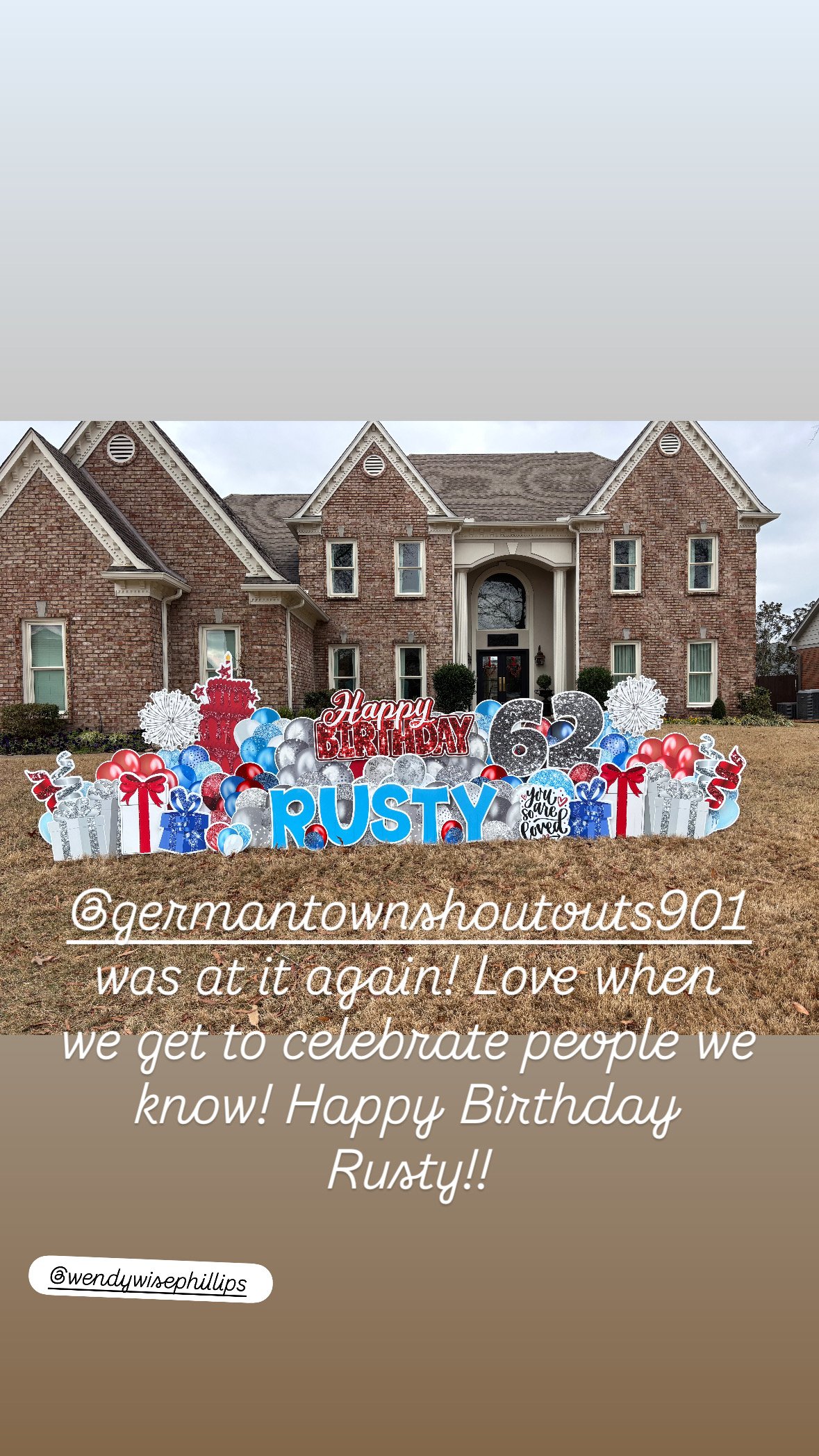 A decorated front yard with a large banner for Rusty's 62nd birthday, featuring red, silver, white, and blue balloons, gift boxes, and birthday signs in front of a brick house.