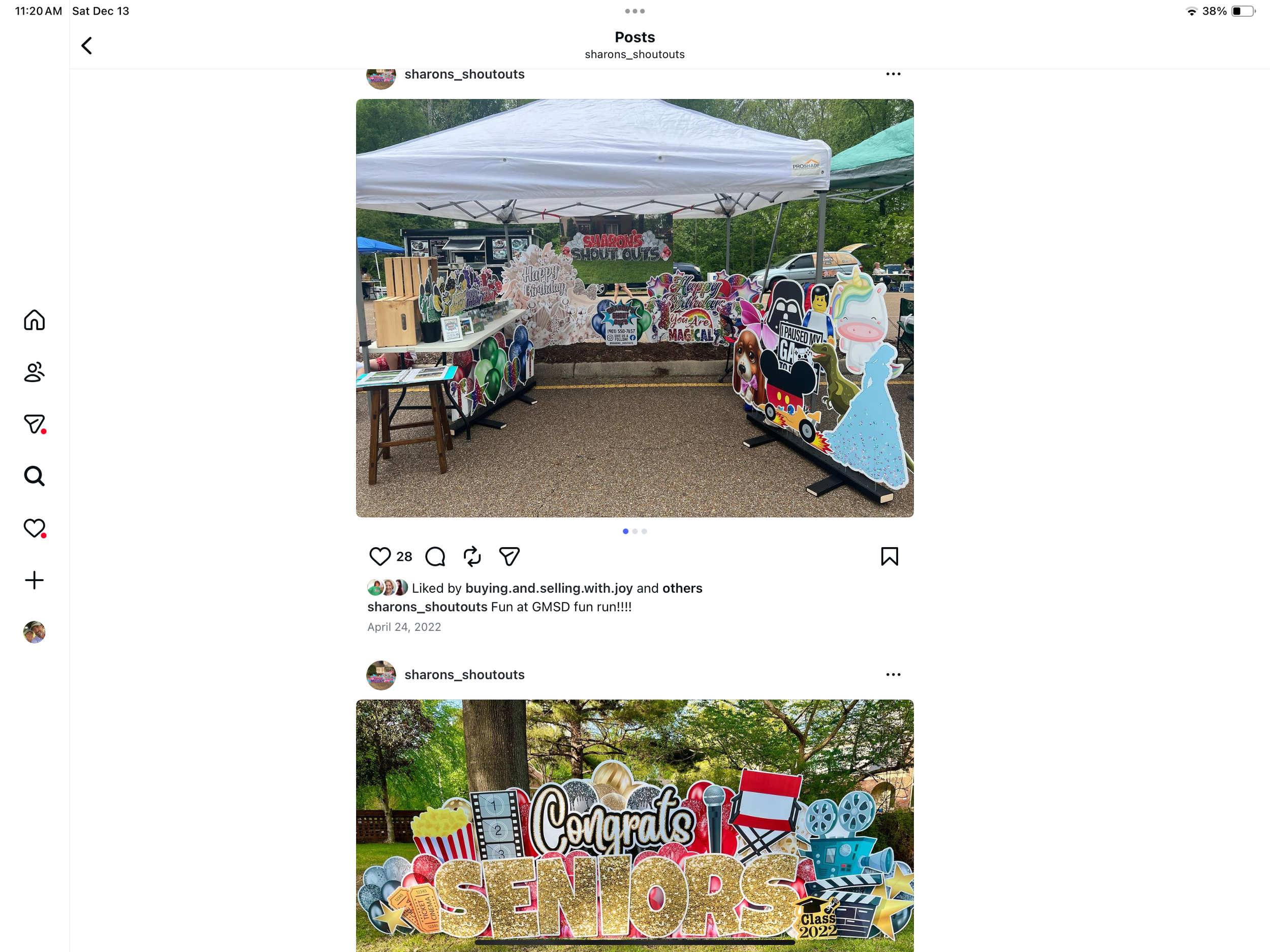 Outdoor celebration booth decorated with colorful signs and cutouts for a kindergarten graduation event, including congratulatory messages and themed graphics, set up under a white canopy in a park.