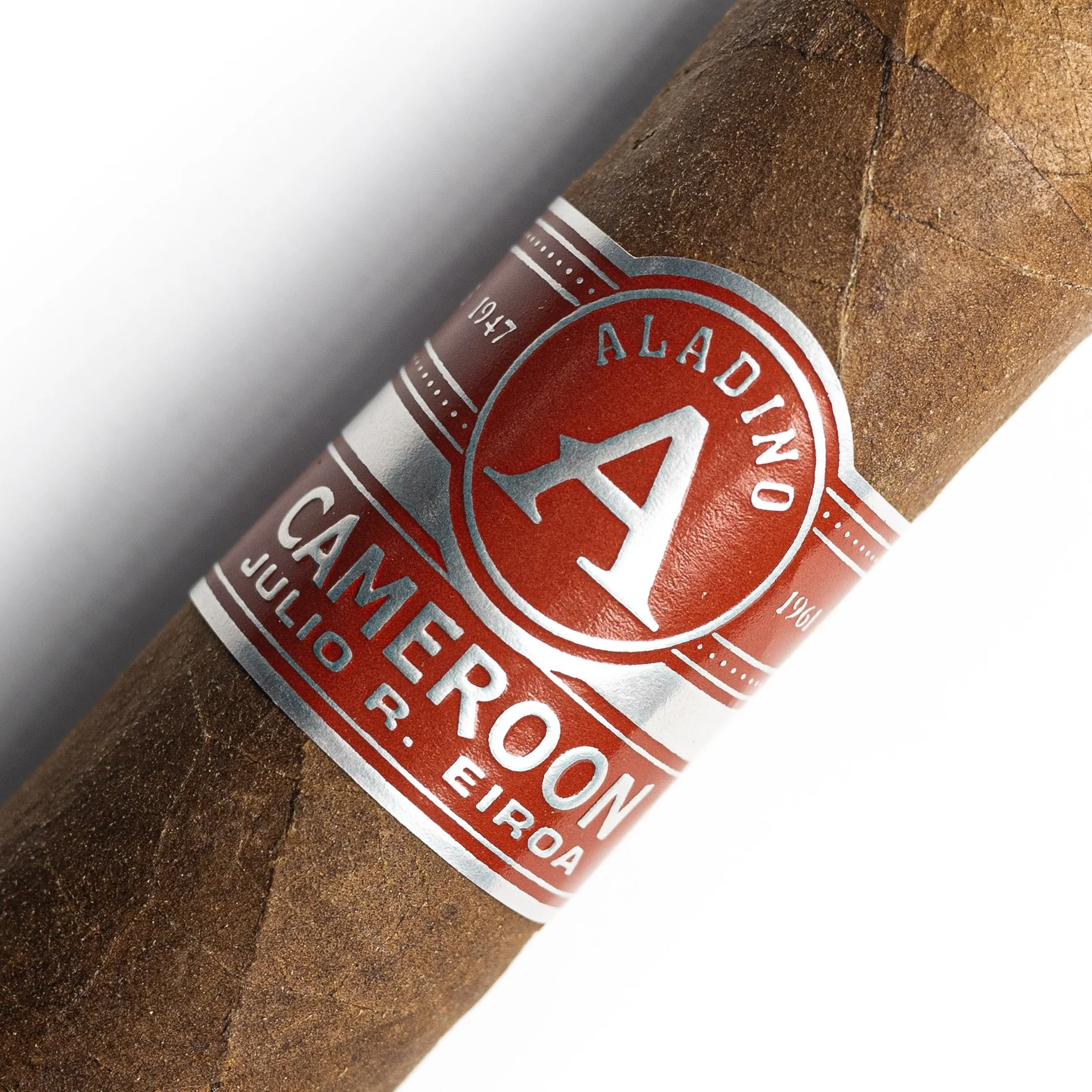 Close-up of a cigar with a red and white band reading 'Aladino' and 'Hecho en U.S.A.' on a brown tobacco leaf.