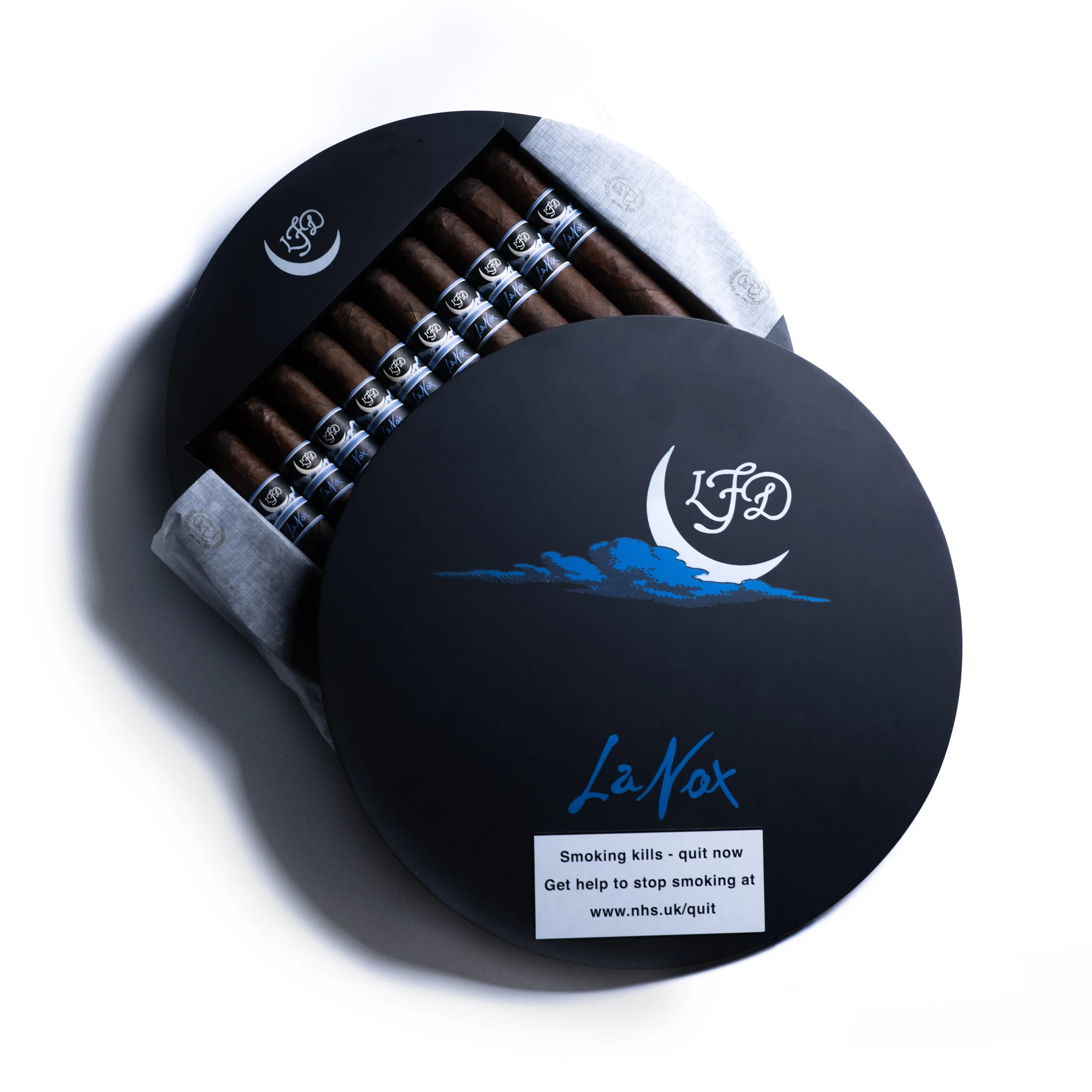 Black box of cigars with a blue logo and a white paper label with a message about quitting smoking, surrounded by white tissue paper.