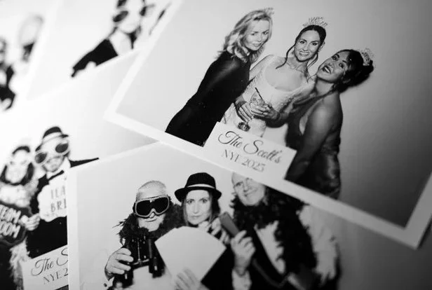 Printed black-and-white photo booth photos featuring groups of guests posing at the photo booth