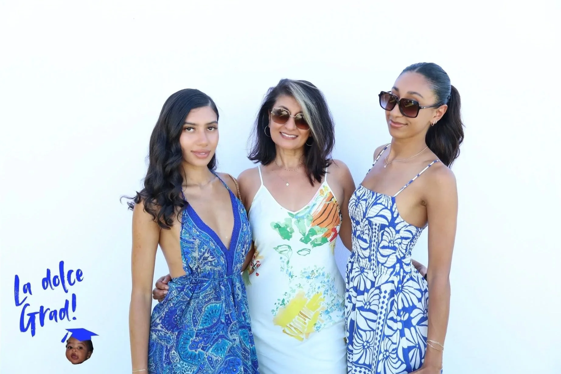 Three guests posing together outdoors at a photo booth event in Bermuda