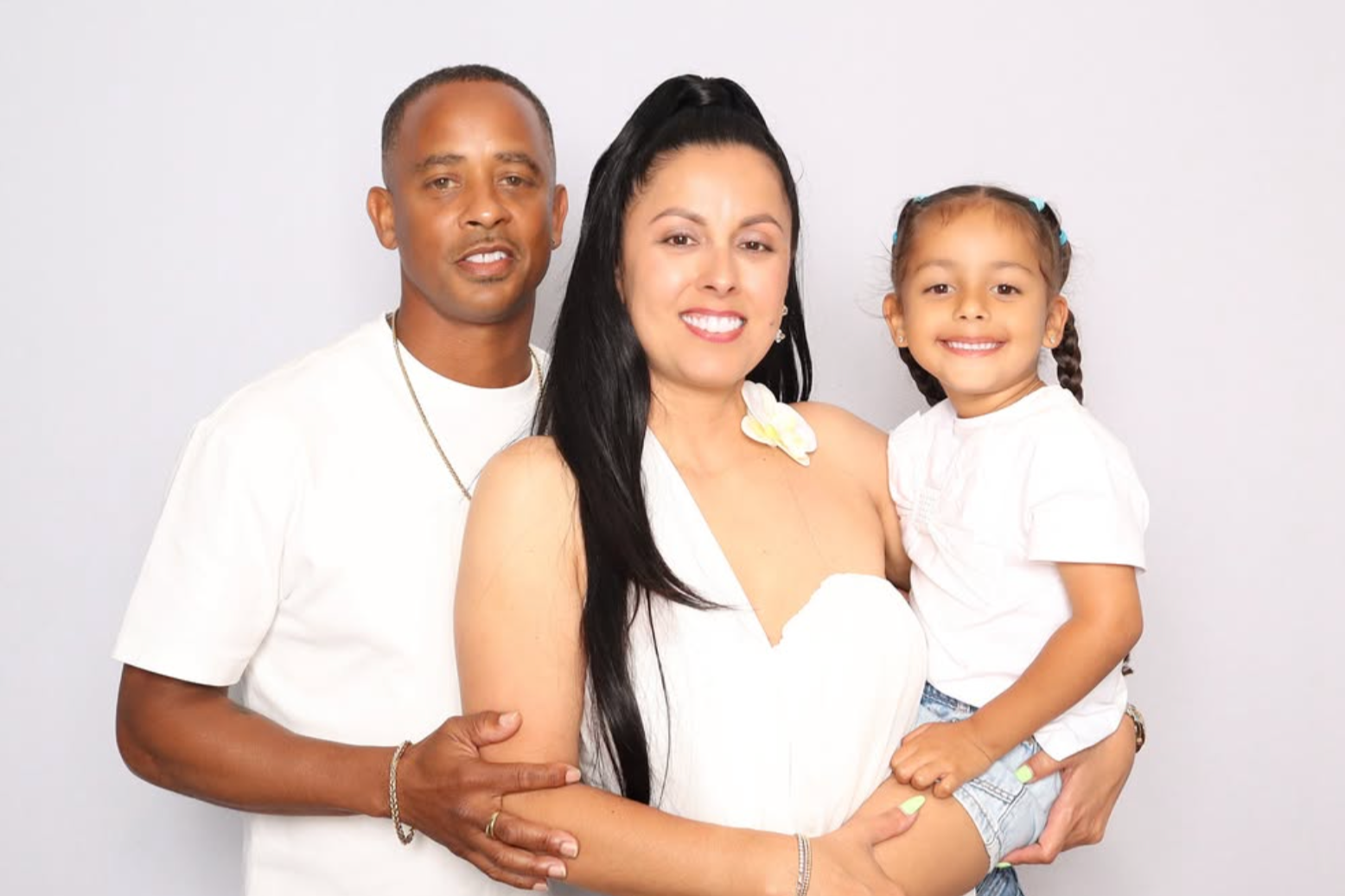 Family of three posing together for a studio-quality photo booth portrait in Bermuda