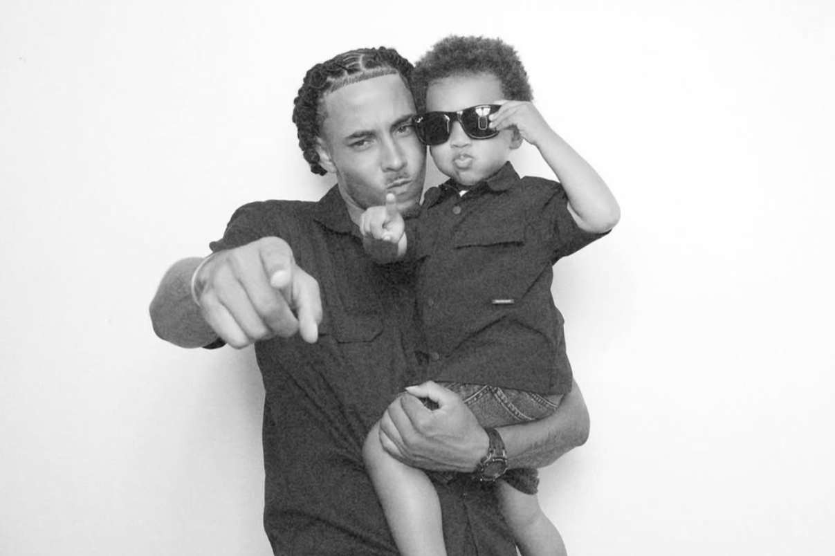 Father holding his young child in a black-and-white photo booth portrait