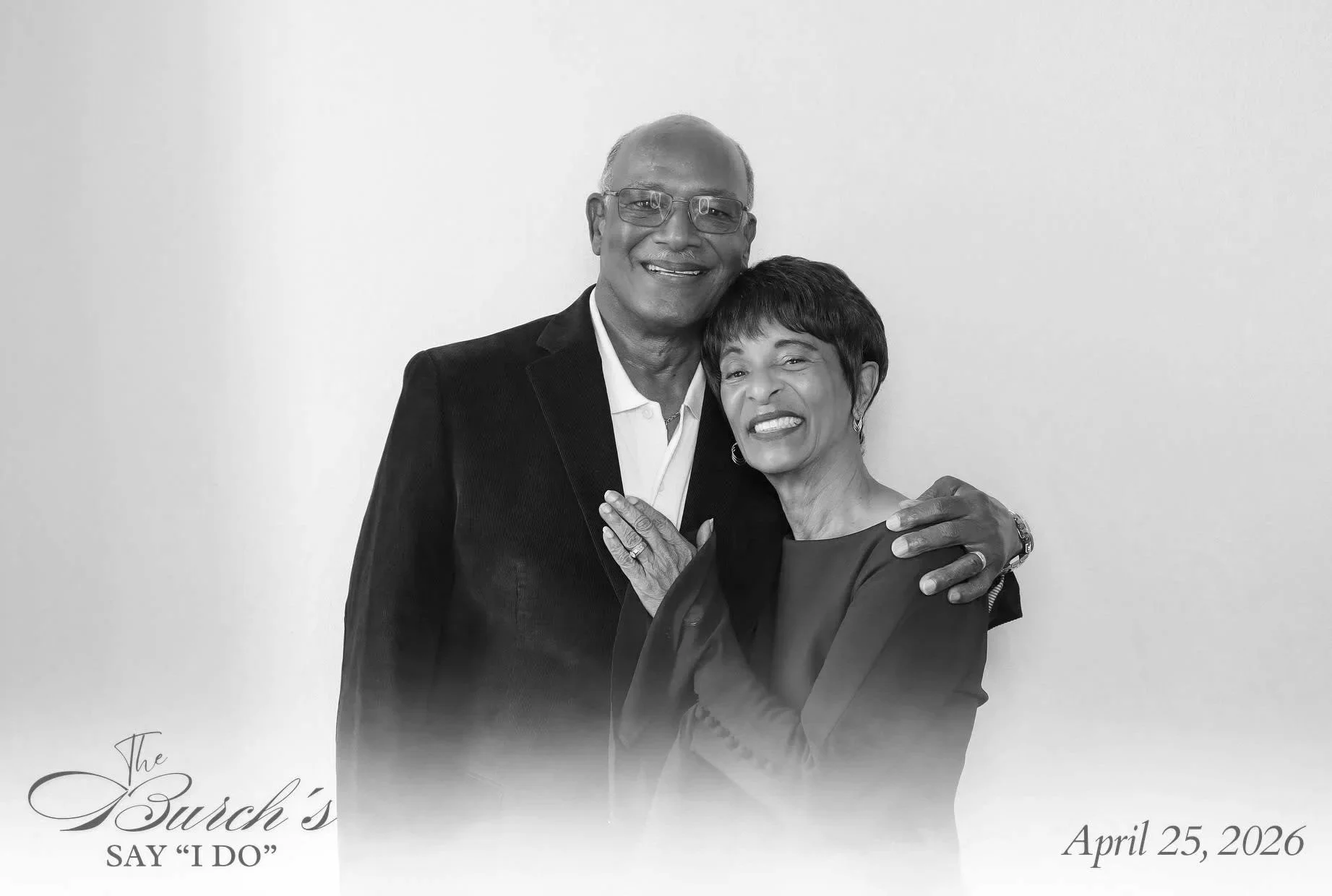 Older Bermudian couple smiling together in a black-and-white photo booth portrait