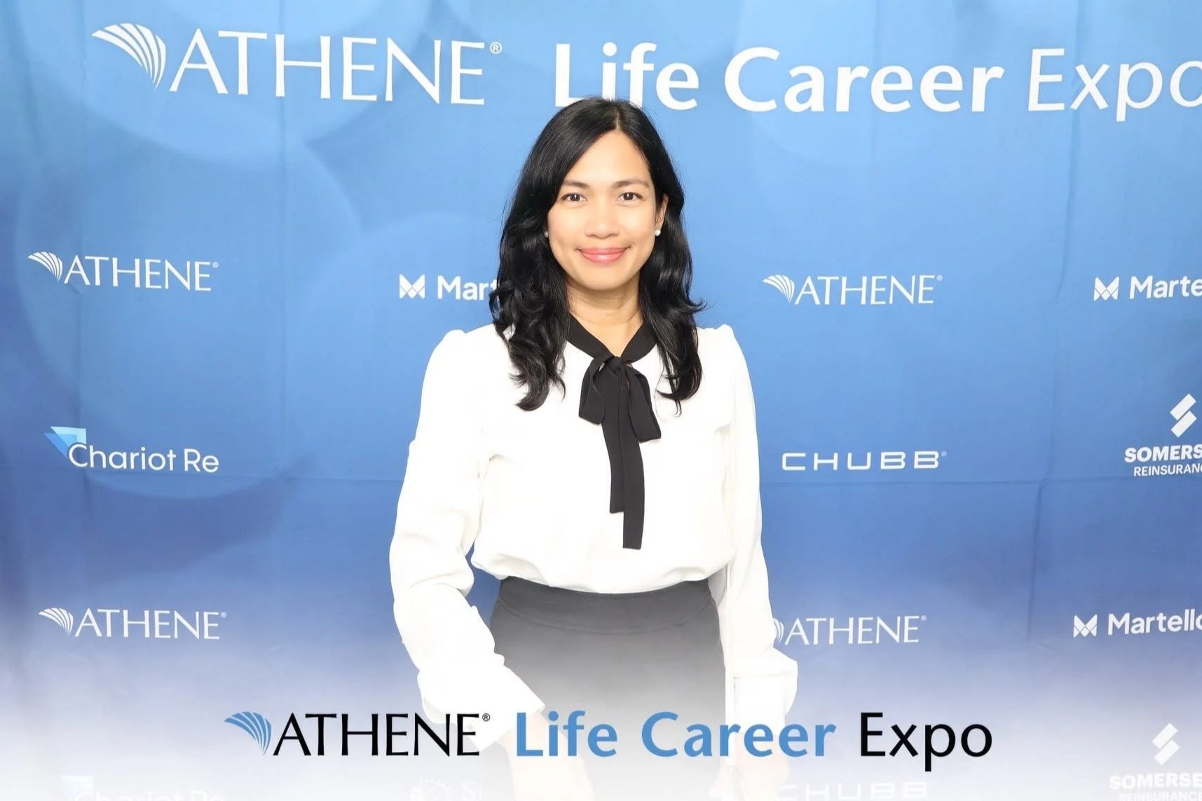 Guest posing in front of a branded corporate event backdrop