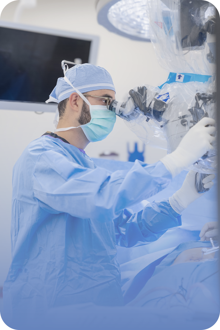 Dr. Hassan A. Fadel at a surgical microscope in the operating room