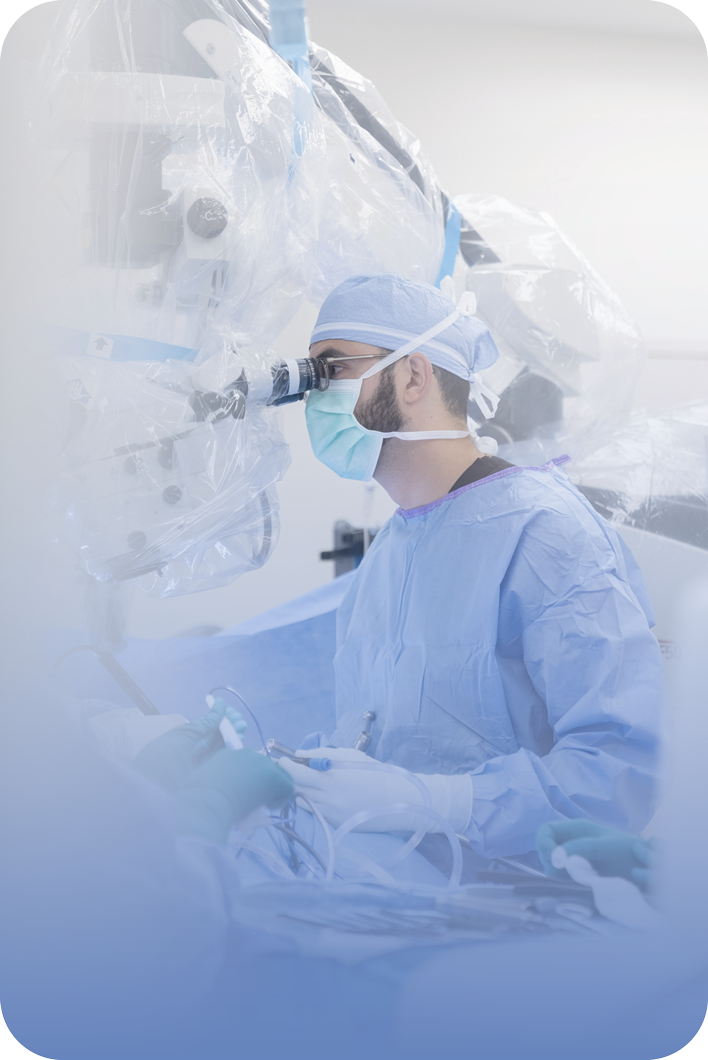 Dr. Hassan A. Fadel operating at a surgical microscope