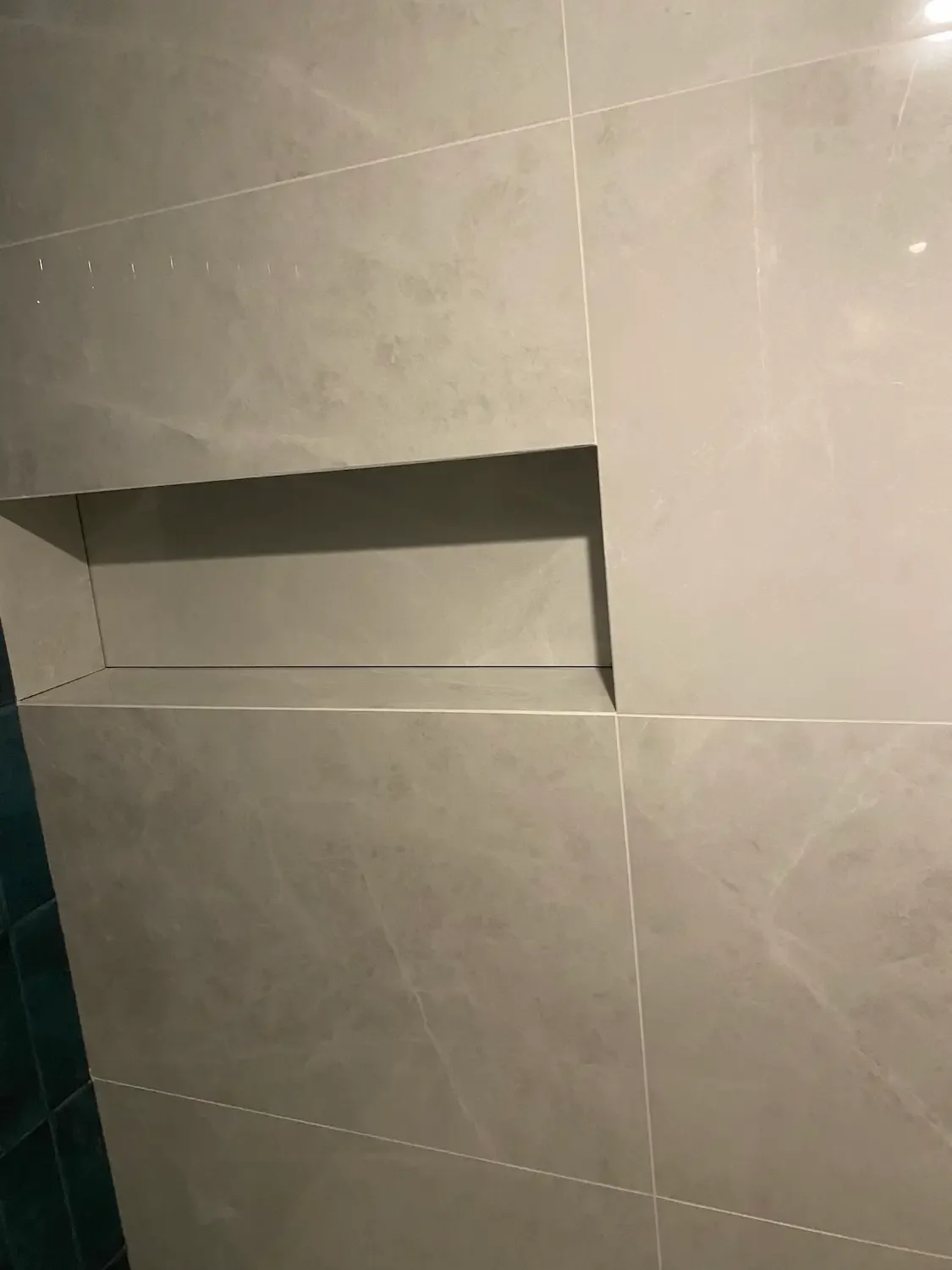 Wnęka łazienkowa wykonana z płytek ceramicznych z precyzyjnym wykończeniem i estetycznymi krawędziami.