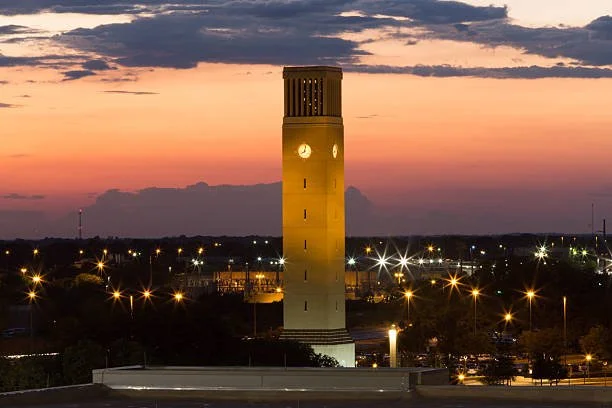 Albritton Tower at Texas A&M University at sunset with lights illuminating the surrounding area.