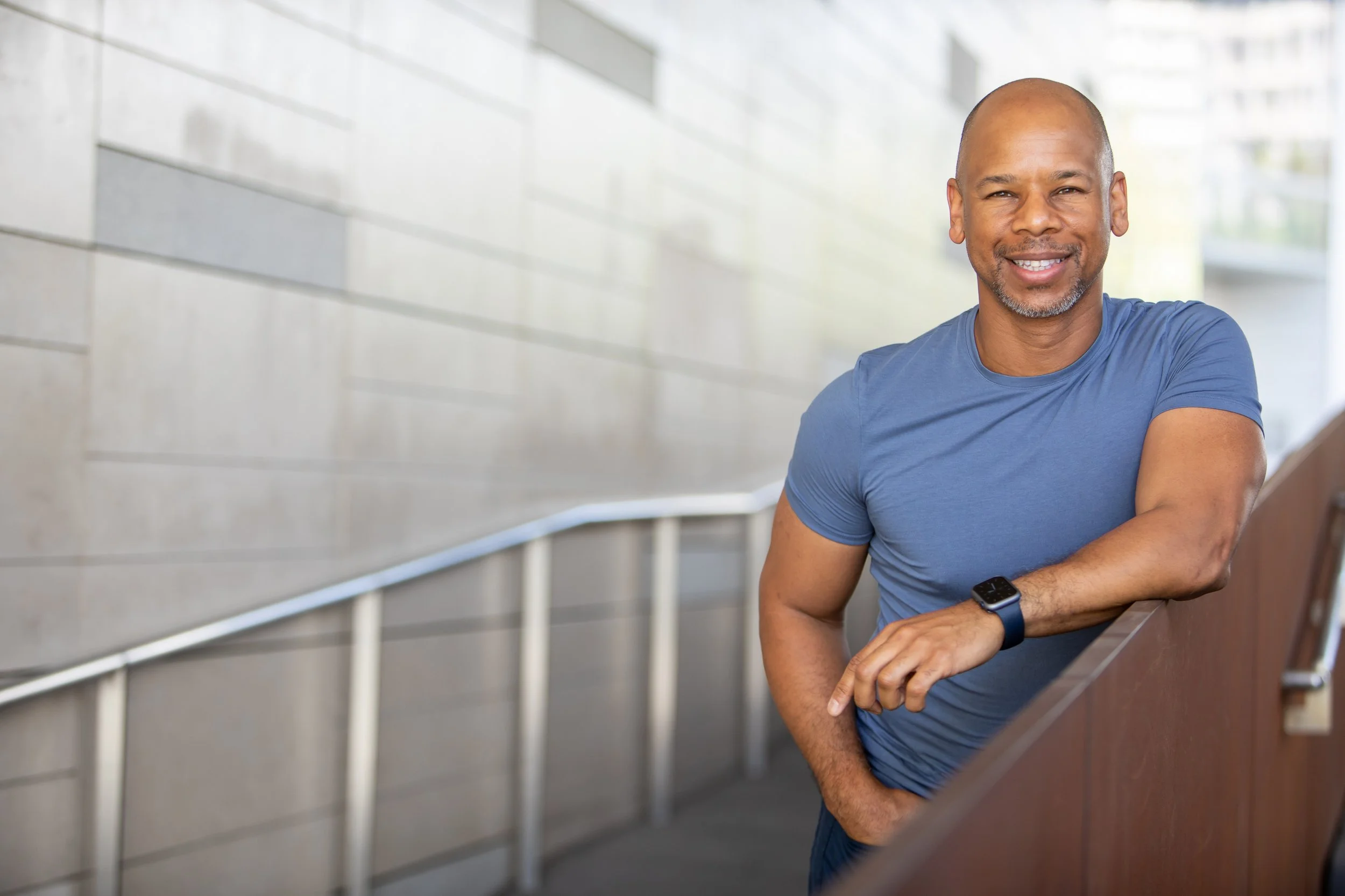 Steven Washington smiling, leaning against a railing.