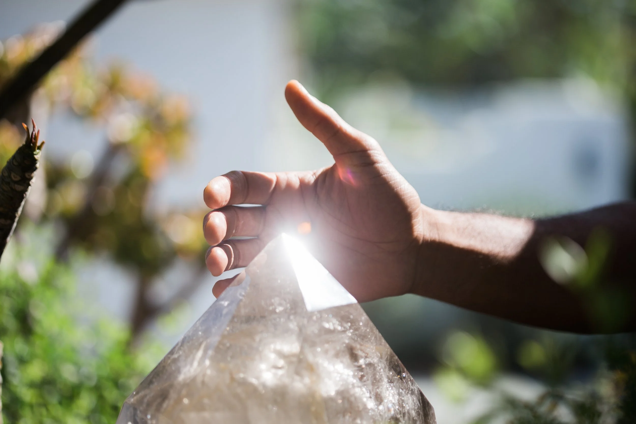 Steven's hand refracting light through a crystal, representing the Transformation Path coaching package