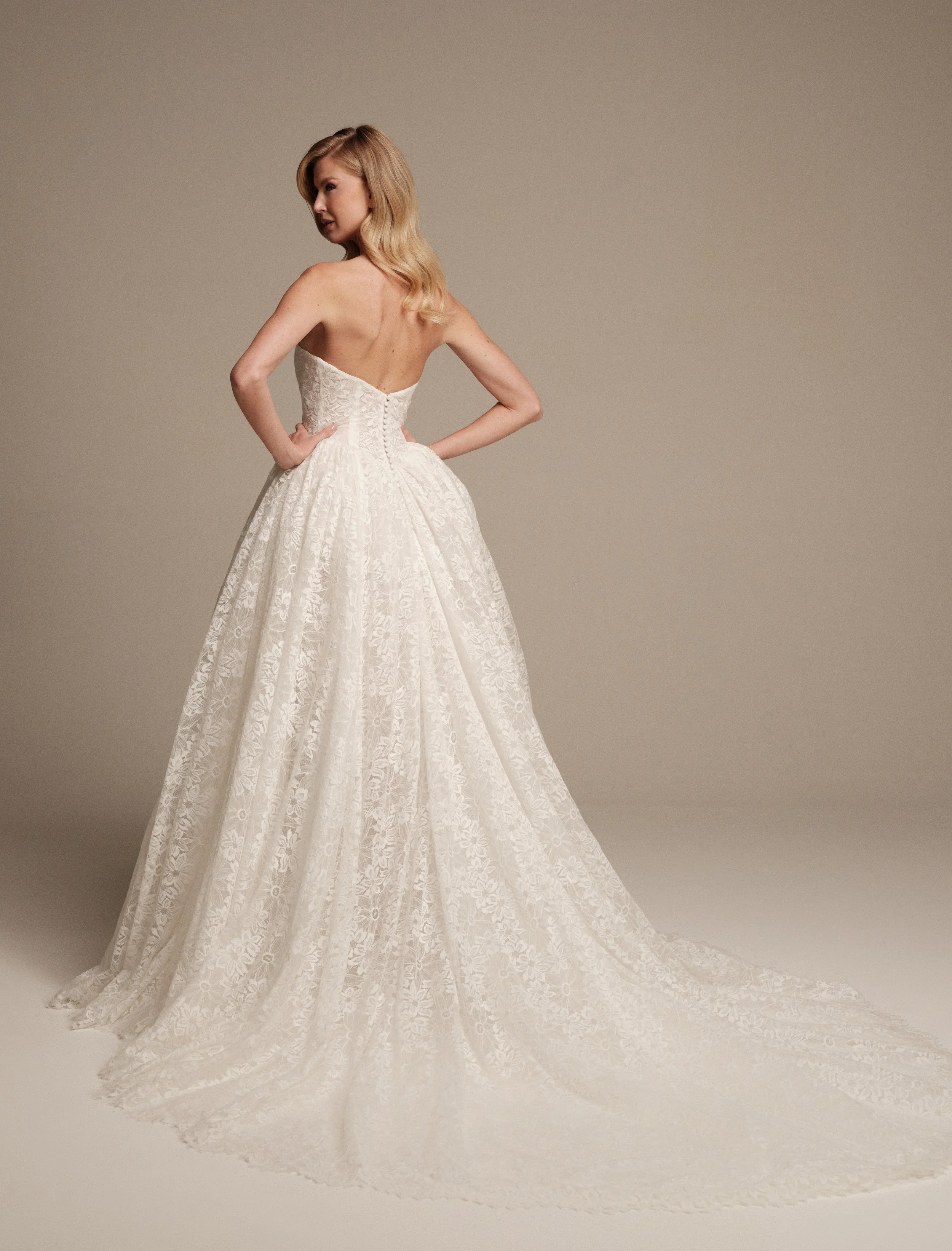 Selene Venise lace wedding dress with full skirt and sweeping train by Maria Pia Bridal, back view
