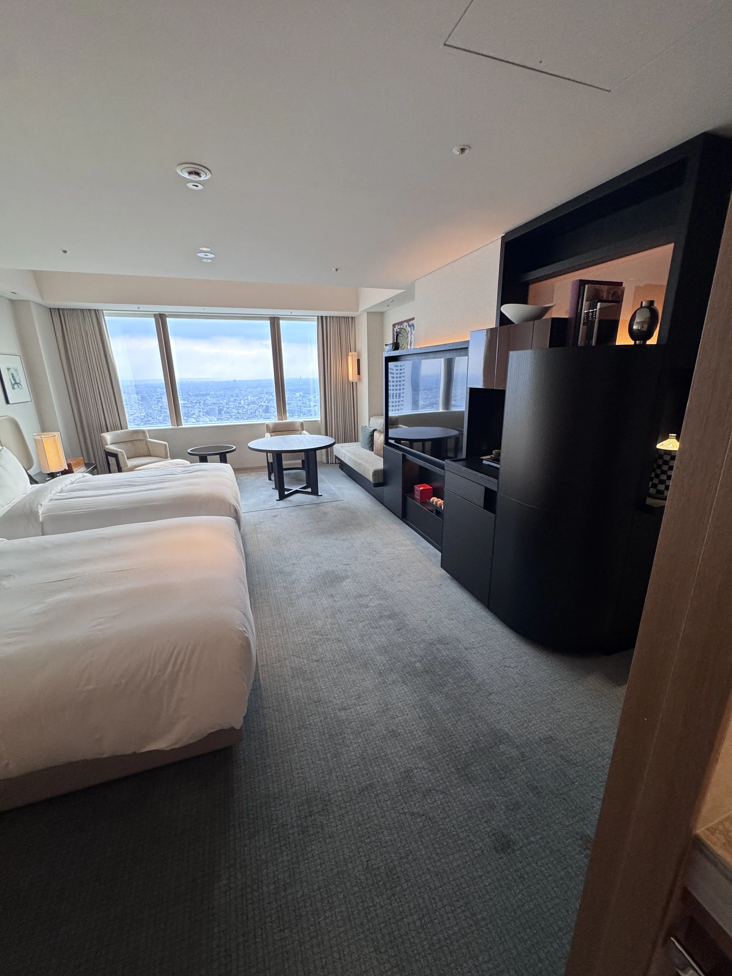 Spacious guest room at Park Hyatt Tokyo with panoramic skyline views and contemporary Japanese décor