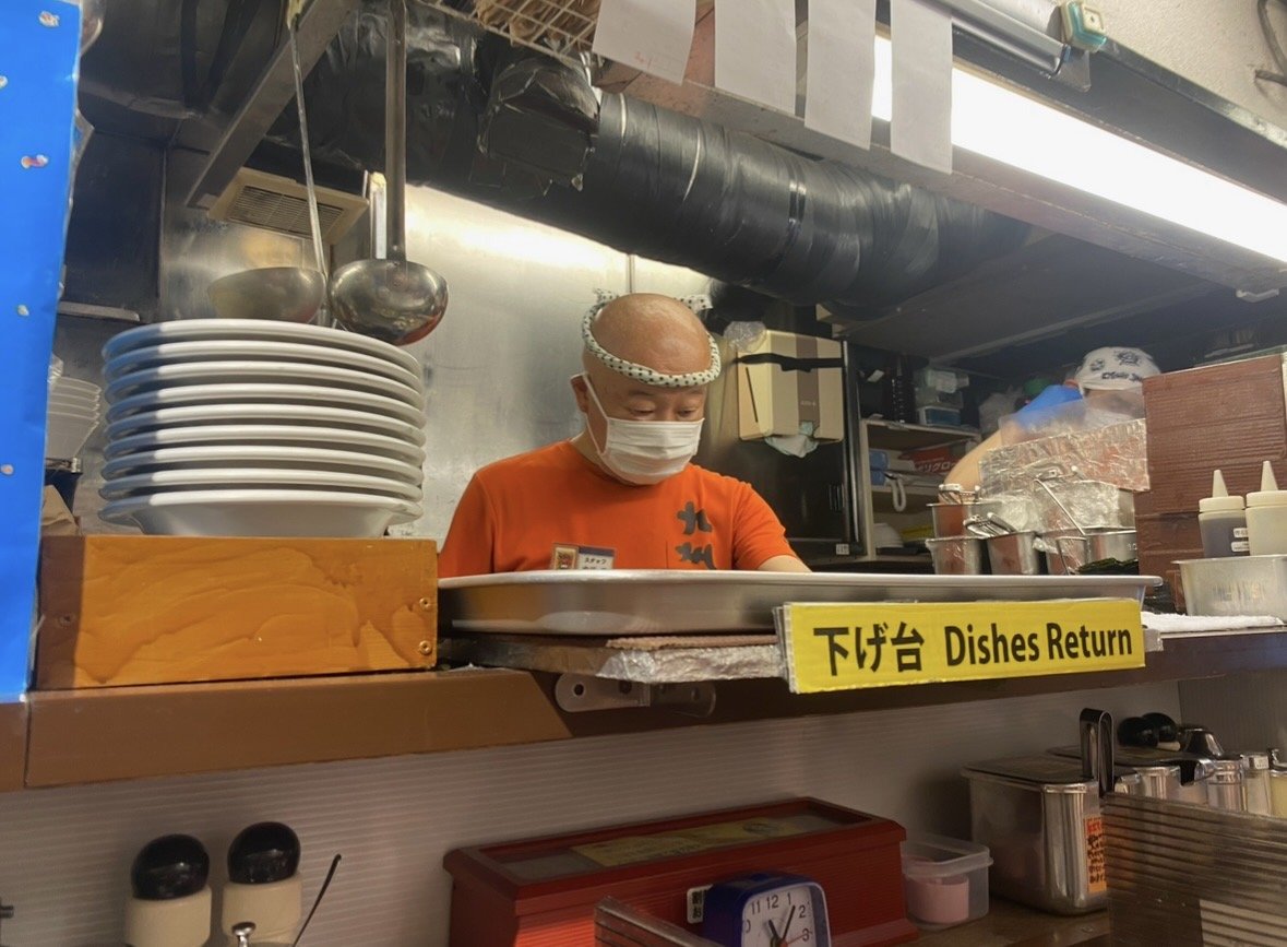 Chef preparing fresh ramen inside Kyushu Jangara Ramen in Tokyo.
