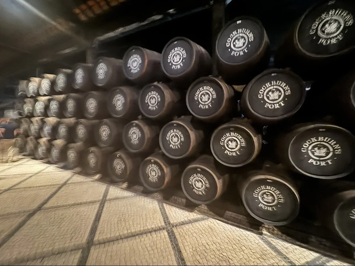 Close-up of stacked port barrels aging at Cockburn’s Lodge in Porto