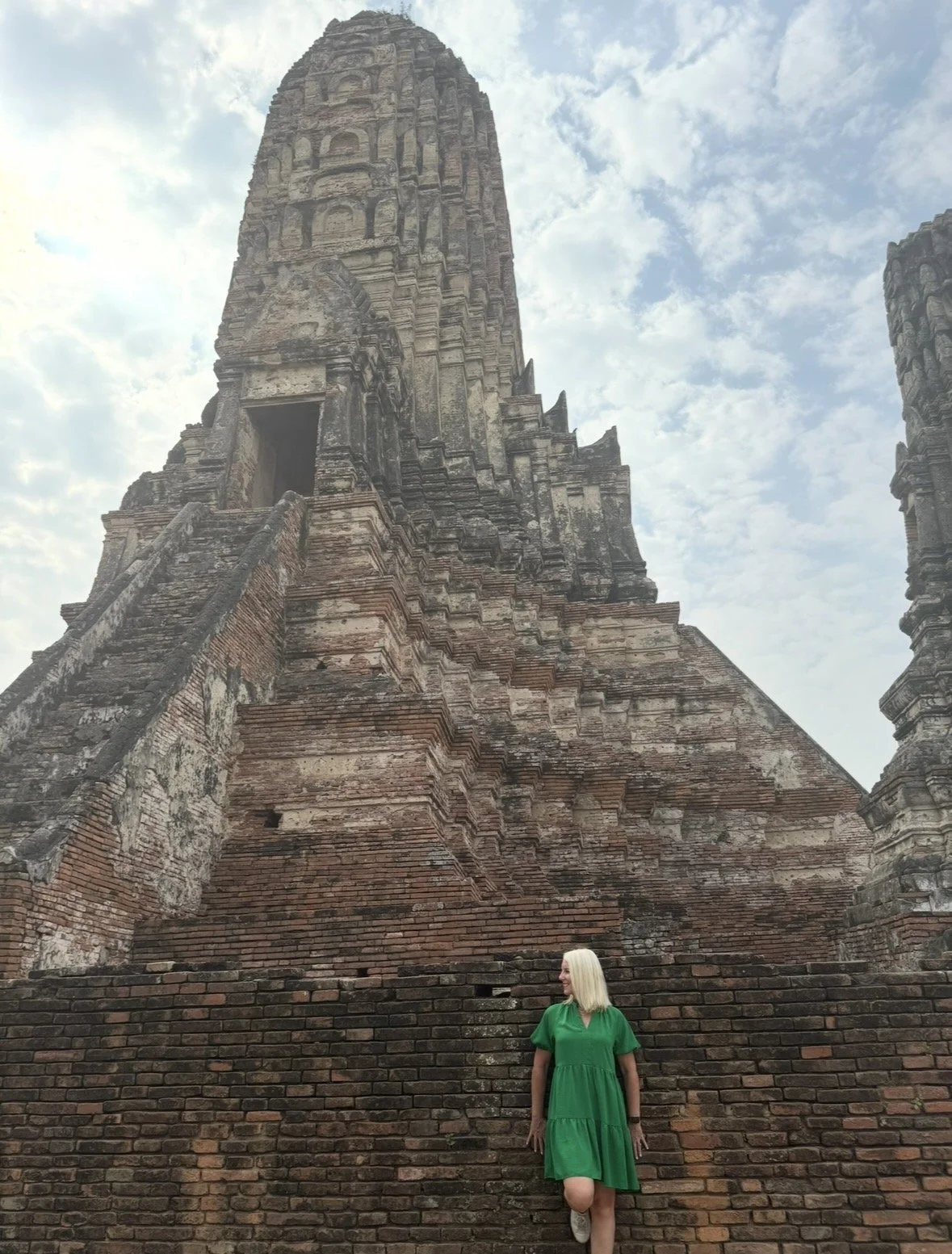 Traveler standing beneath the towering ruins of Wat Maha That in Ayutthaya Historical Park Thailand