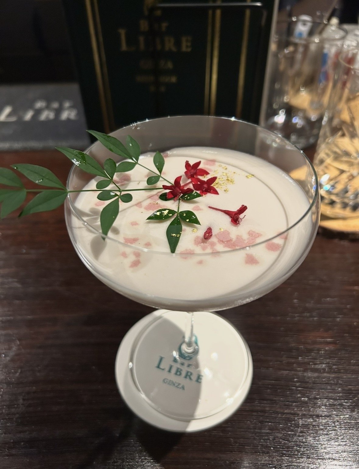 Floral cocktail decorated with greenery, red flowers and gold at Bar Libre Ginza