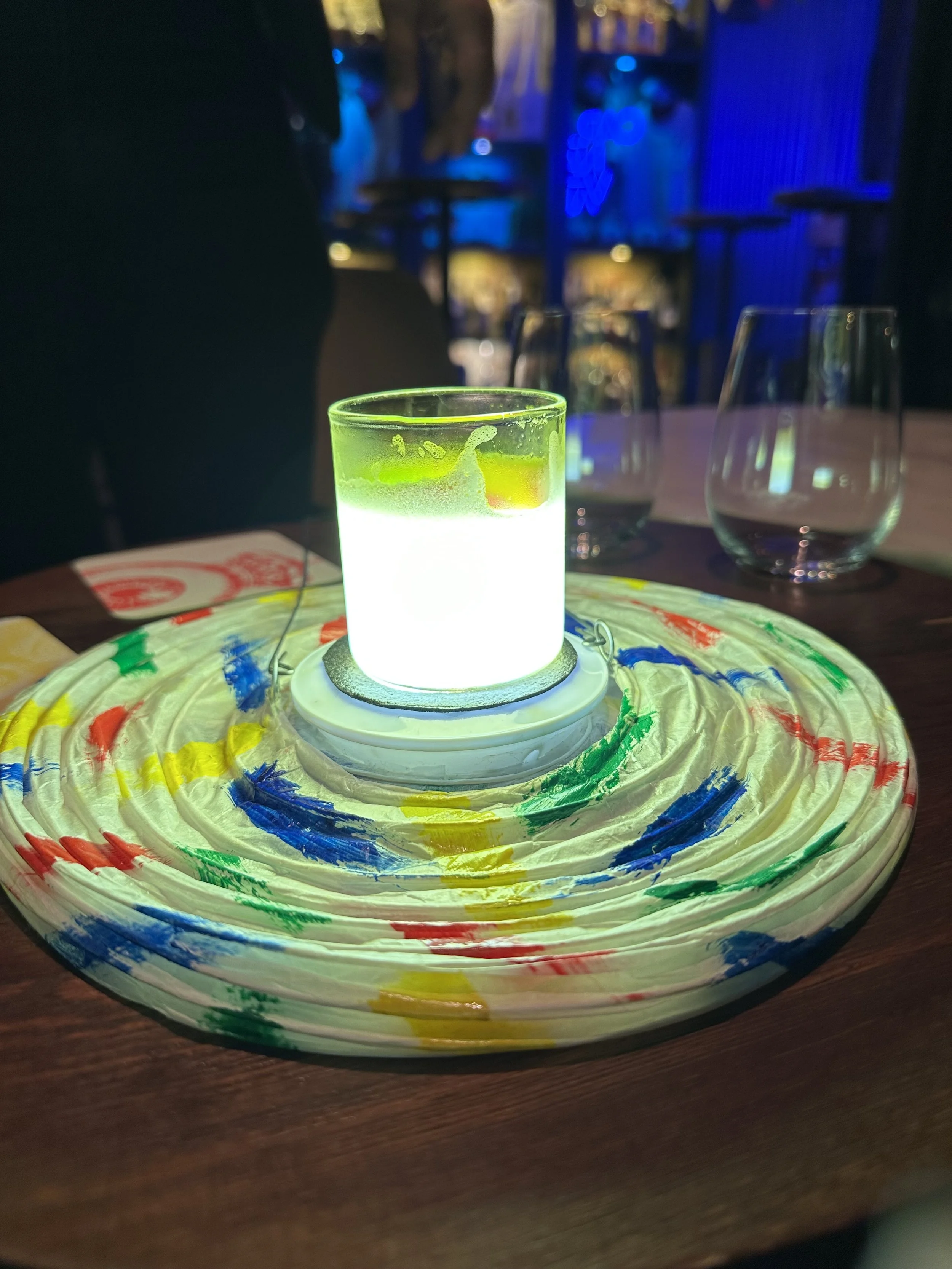 Creative cocktail presentation served on a colorful artistic platter at Carnaval Bar