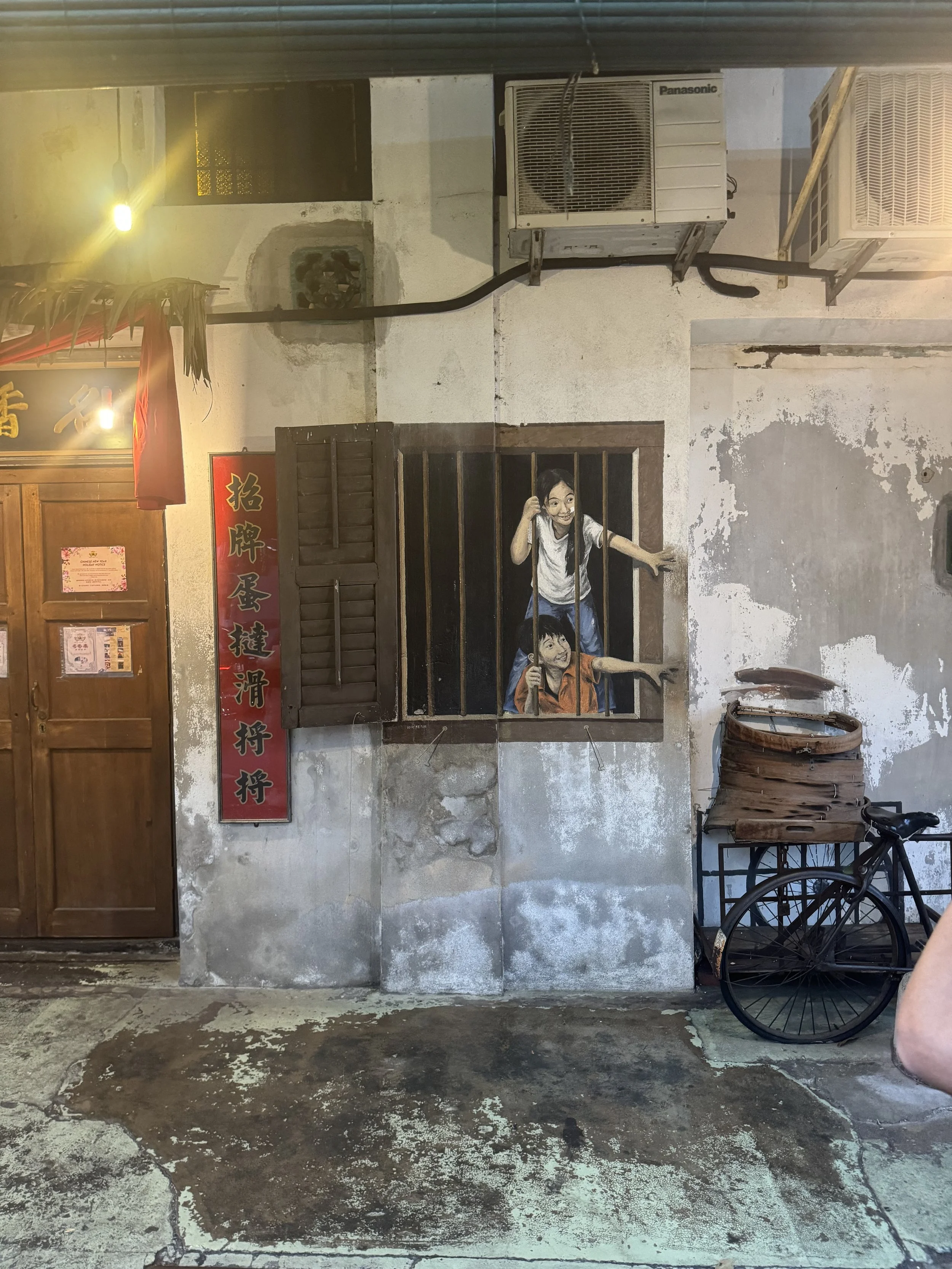 Children peeking from window mural in George Town Penang