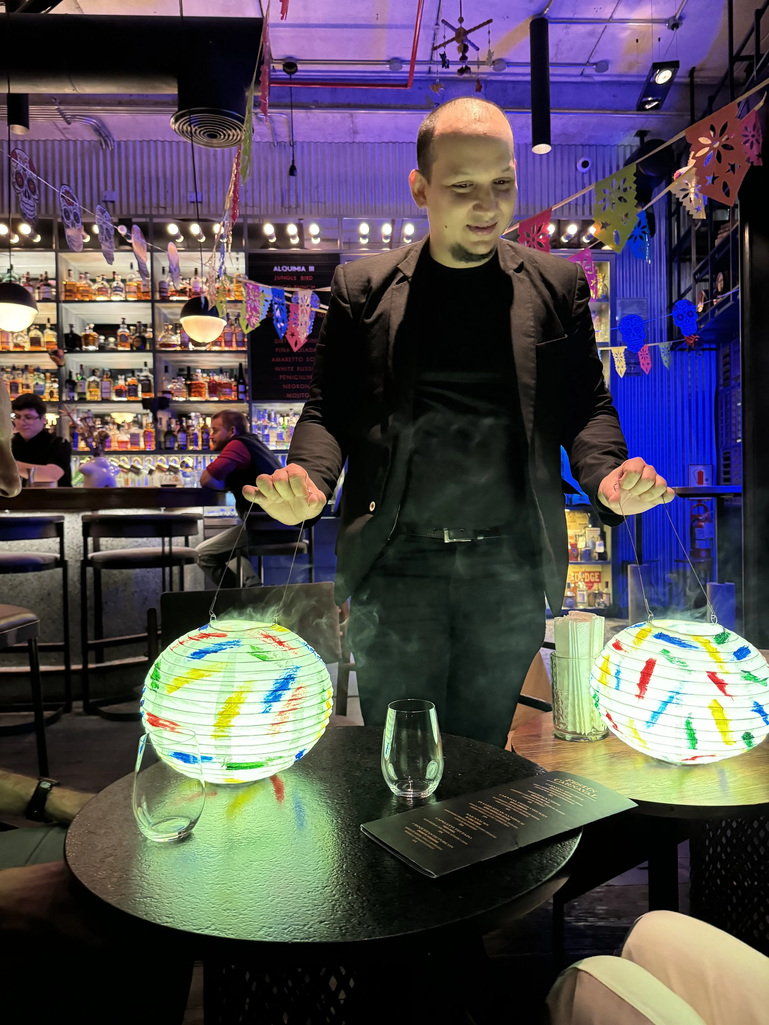 Bartender presenting an immersive cocktail experience at Carnaval Bar in Lima, Peru.