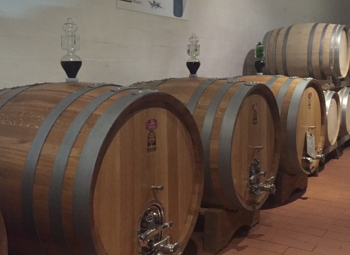 Oak wine barrels aging Chianti Classico wines at Casa Emma Winery