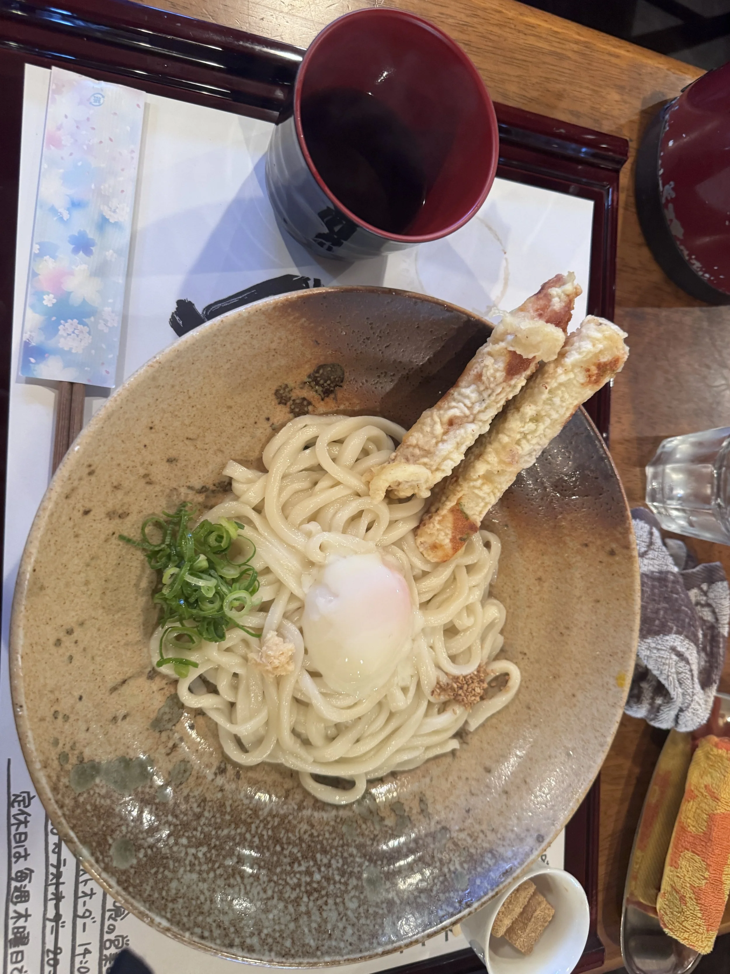 Fresh Japanese noodles with soft egg and tempura fish cake during lunch in Nara