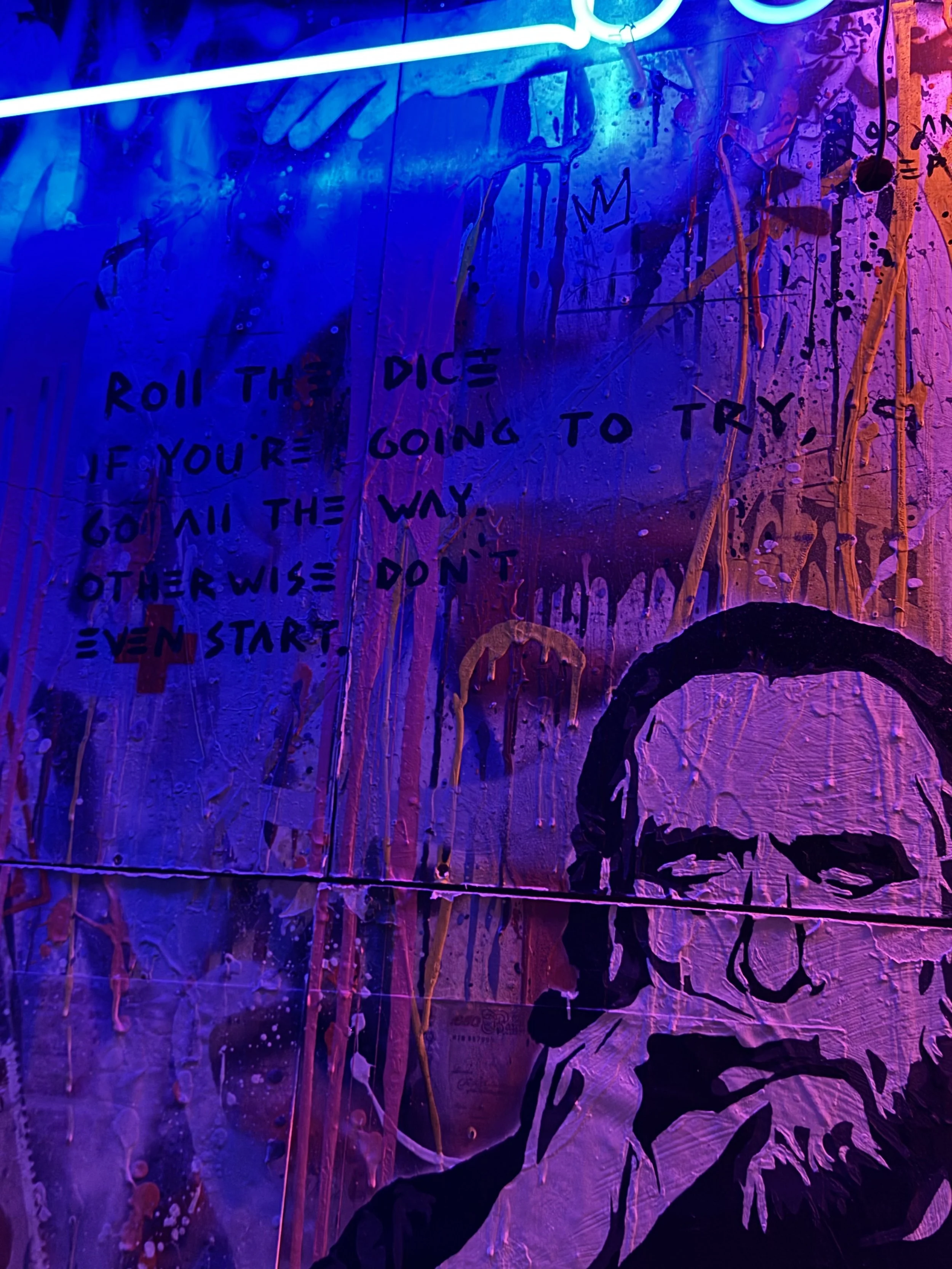 A graffiti-style artwork with vibrant purple, pink, and blue colors featuring abstract paint splatters and streaks, with handwritten text that reads: 'Roll the dice if you're going to try, go all the way otherwise don't even start.'