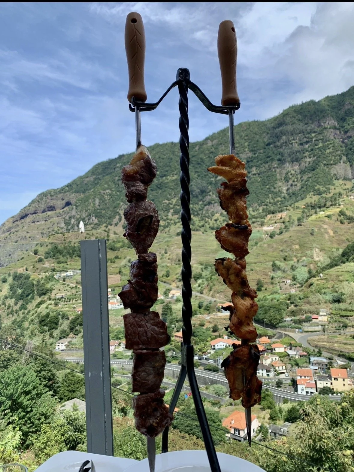 Traditional Madeiran espetada beef skewers served at Larador Restaurant with panoramic mountain views in Madeira.