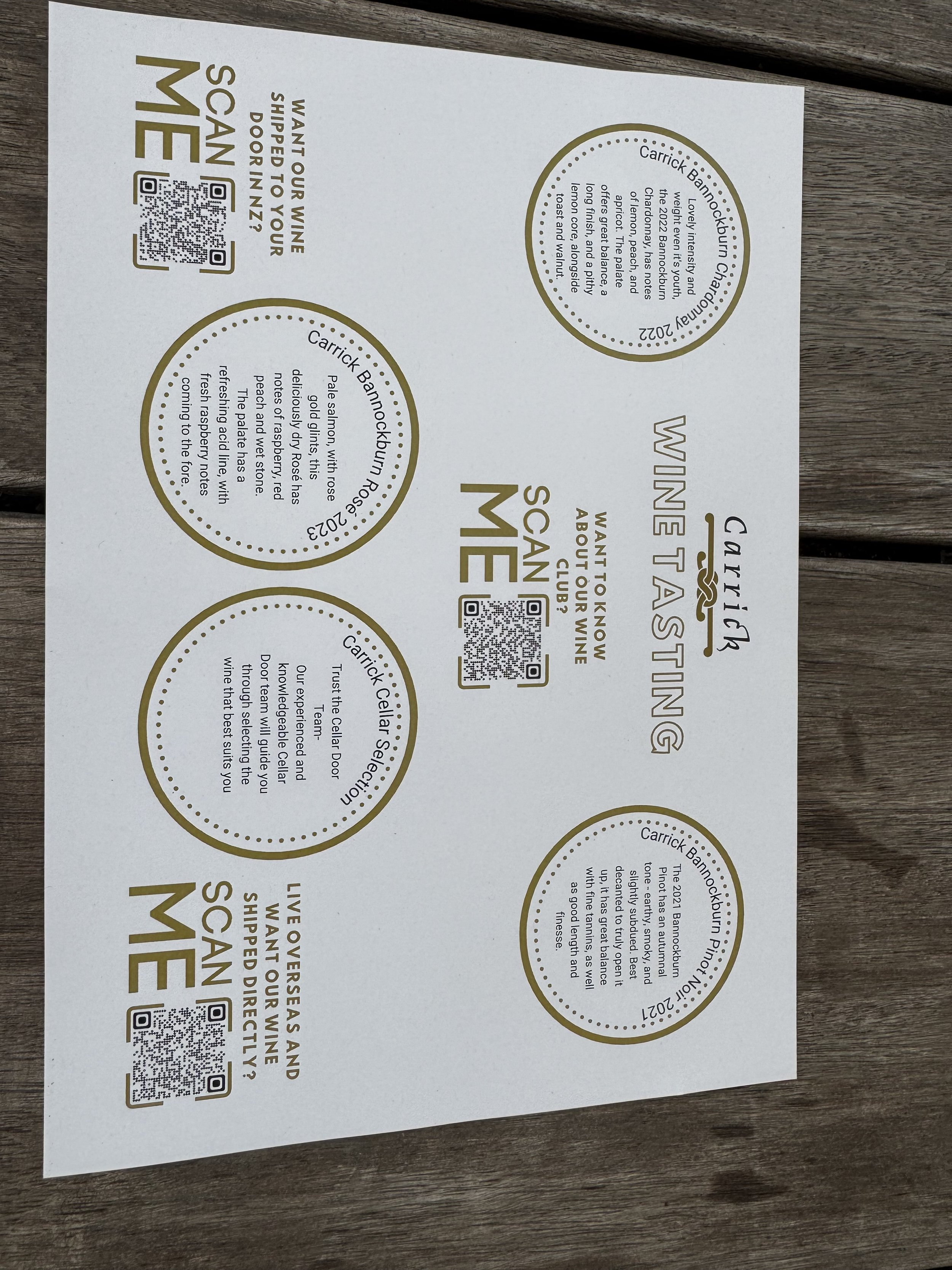 A promotional flyer with gold and black text on a white background, featuring circular sections with information and QR codes about a wine tasting event at Carrick Bannockburn. The flyer includes details about the event date, winery, and a brief description of the wines.