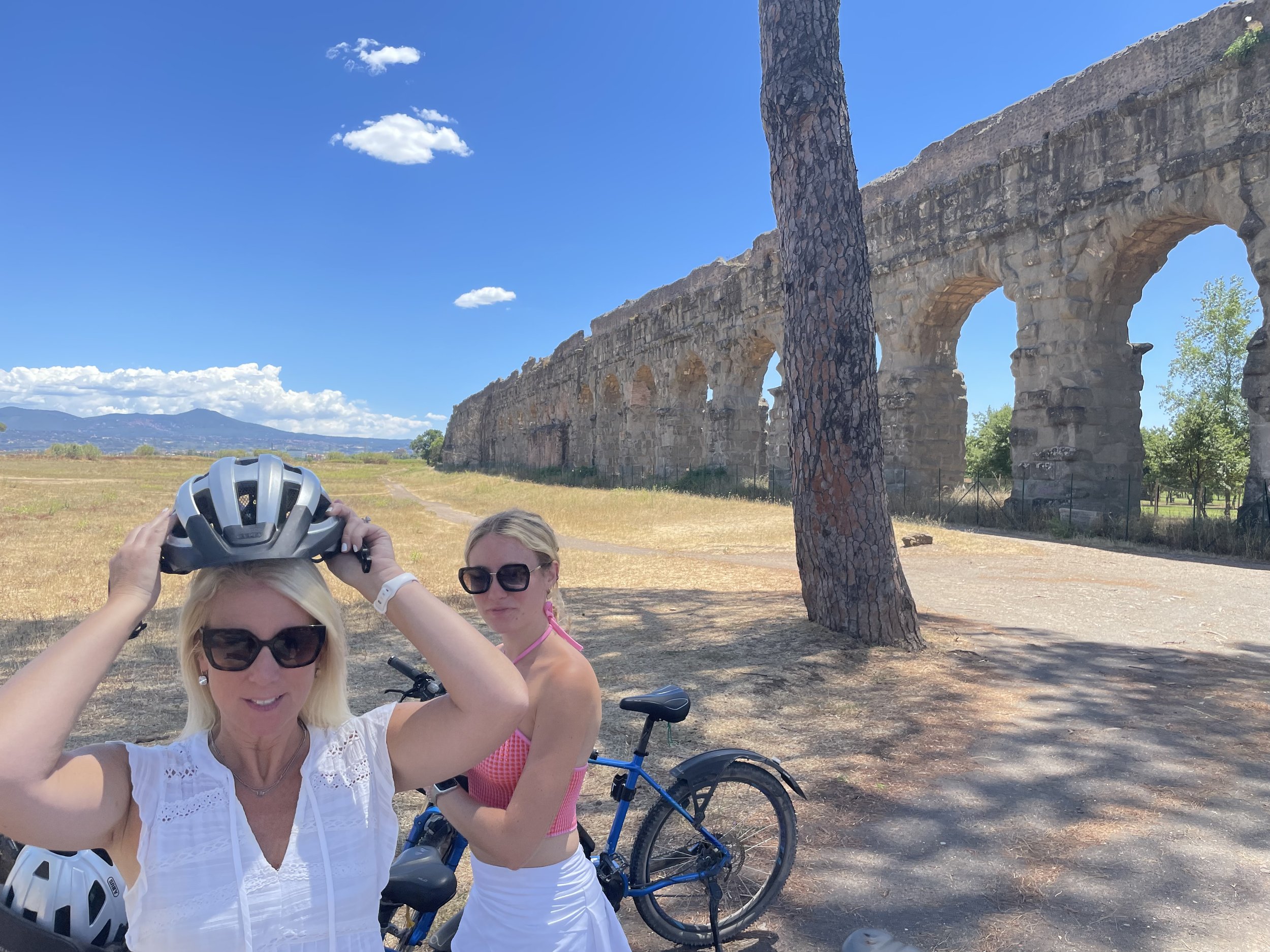 Cyclists stopping beneath the ancient aqueducts along the Appian Way