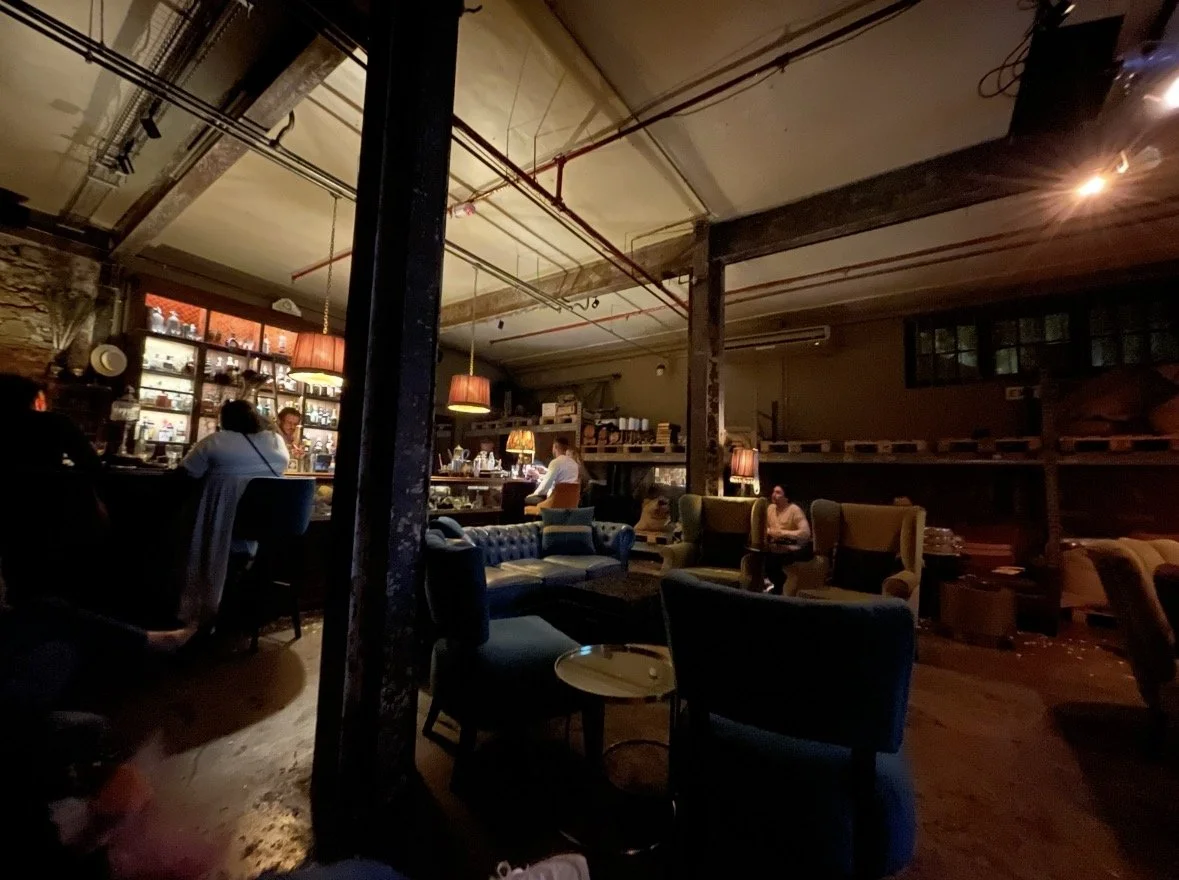 Moody interior of The Art of Duplicity in Cape Town with lounge seating and cocktail bar